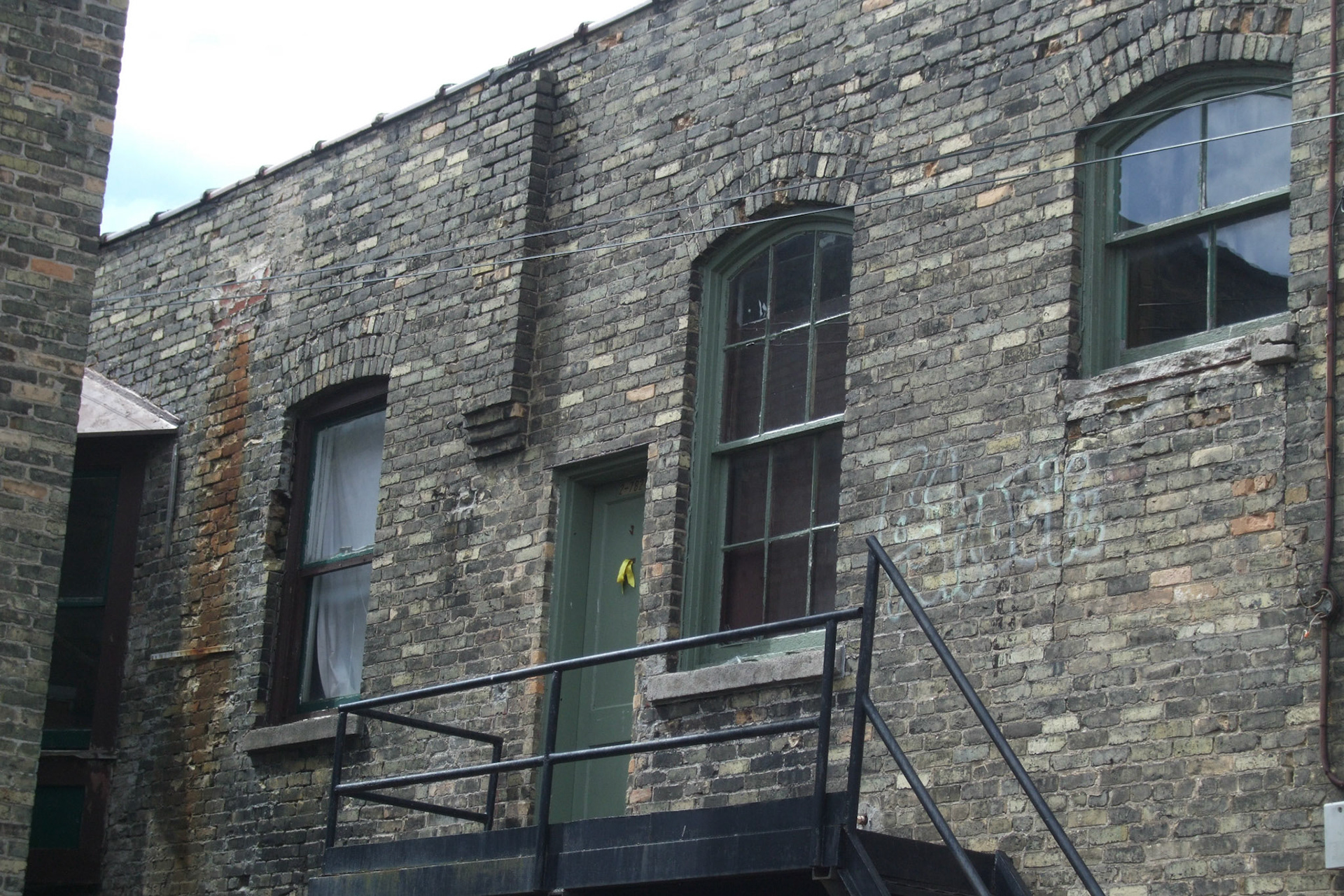 Detail of an apartment in the back alley. Amazing windows and brickwork