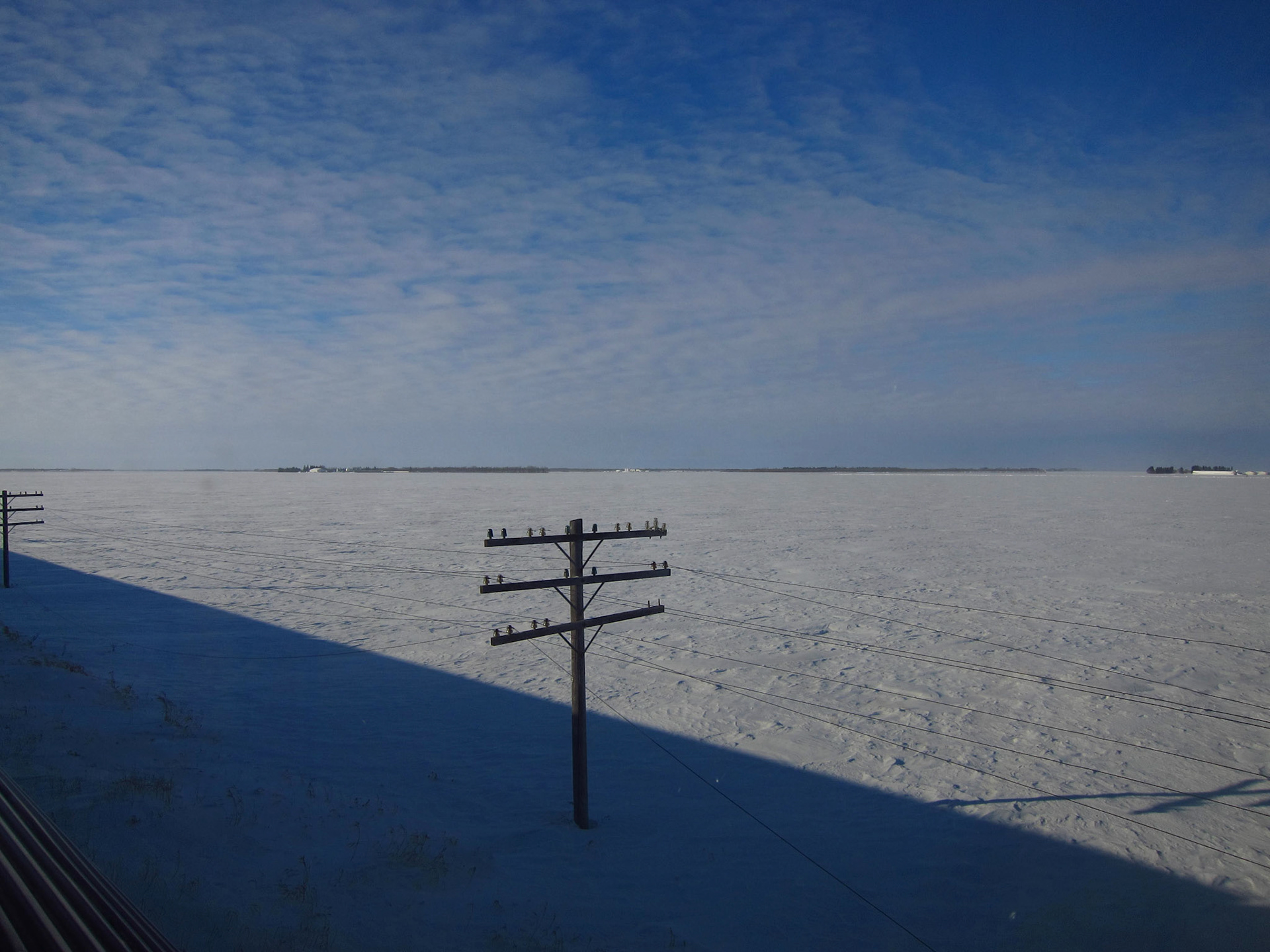 Endless fields of snow and blue sky in the prairies