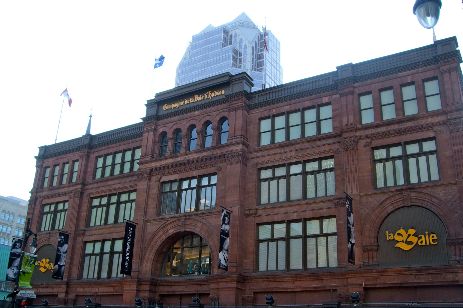 A modern skyscraper emerges behind the older architecutre of the beautiful Bay department store