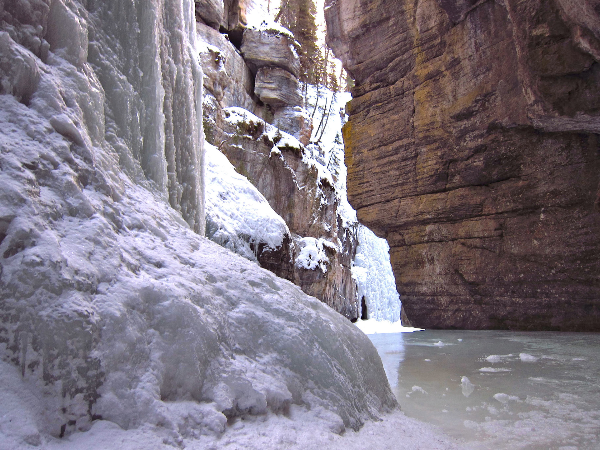 Walking back out of the Maligne Canyon along the frozen river with the towering walls of ice