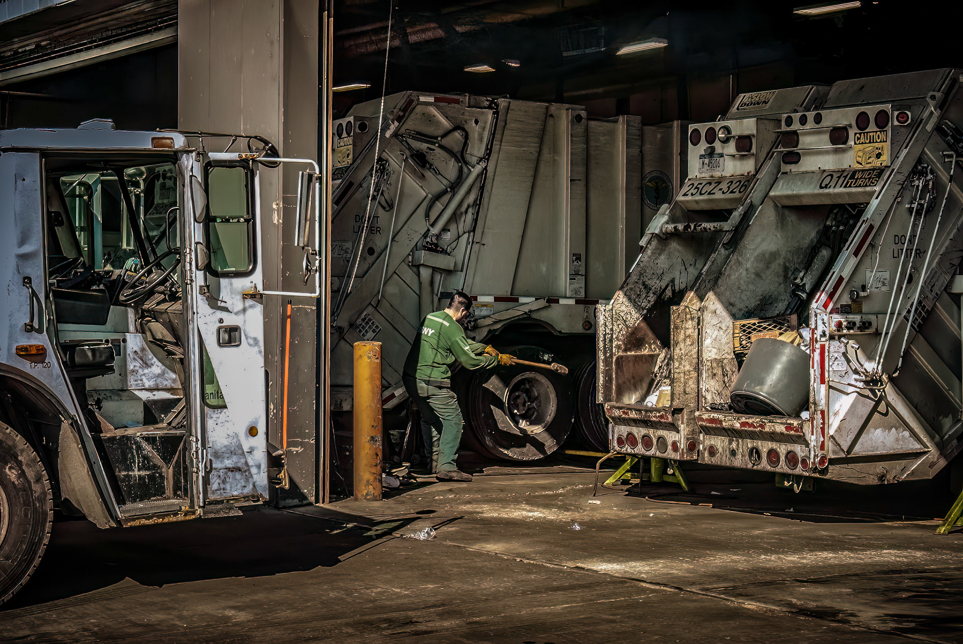 Sanitation Worker Fixing a Wheel
