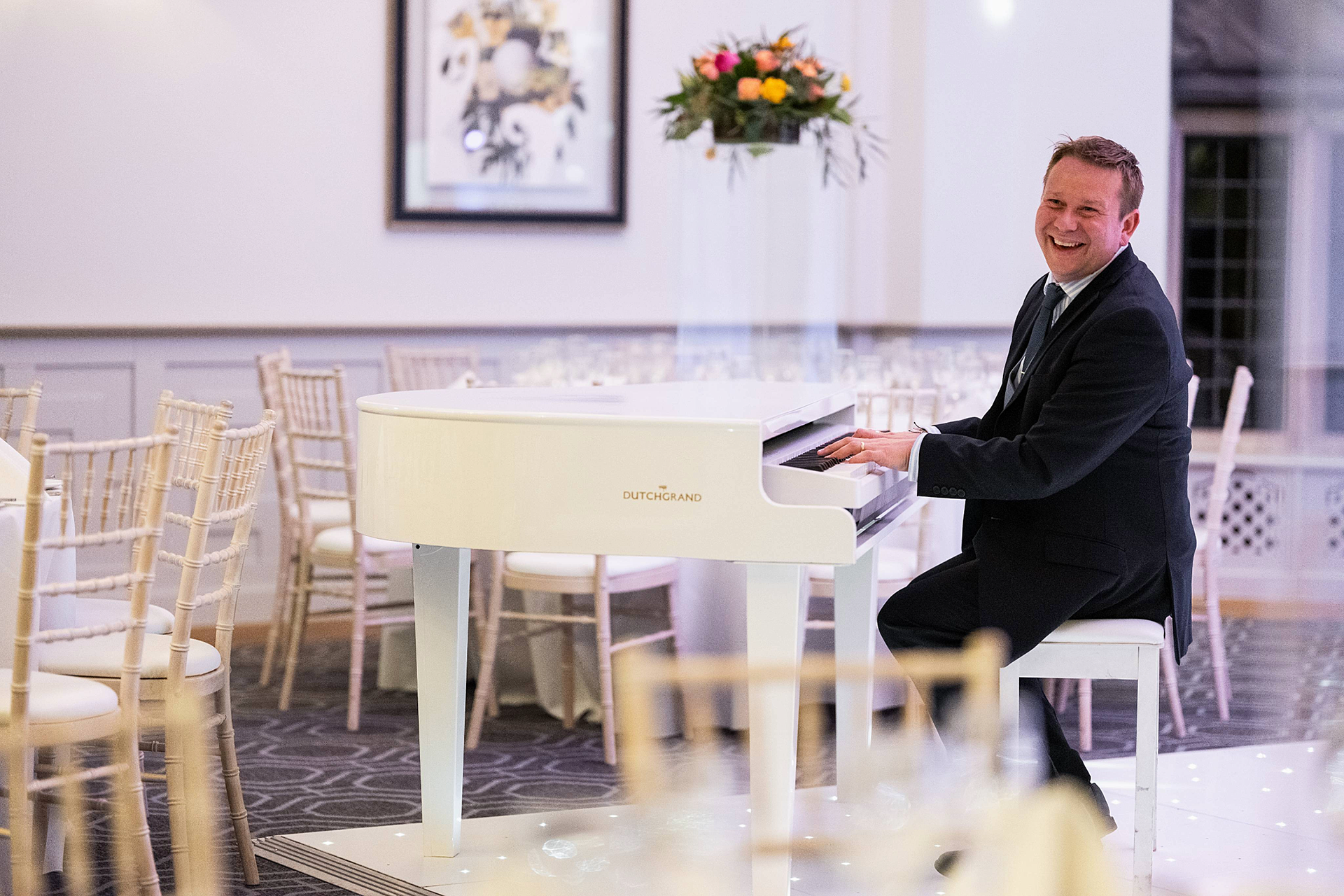 Phil Morton performing on a white DutchGrand piano during a wedding ceremony in Sussex