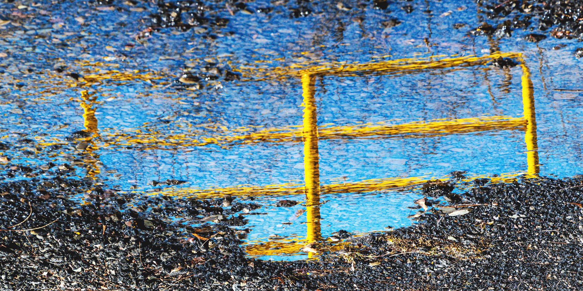 Reflecton of Yellow Gate in Puddle