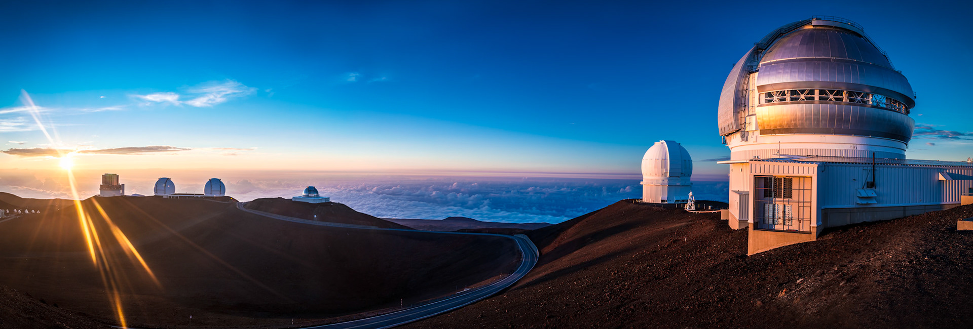 Sunset on Hawaii's Big Island Mauna Kea volcano. The 4,200 meter high summit houses the world's largest observatory for optical, infrared, and submillimeter astronomy. Panoram stiched from 8 images