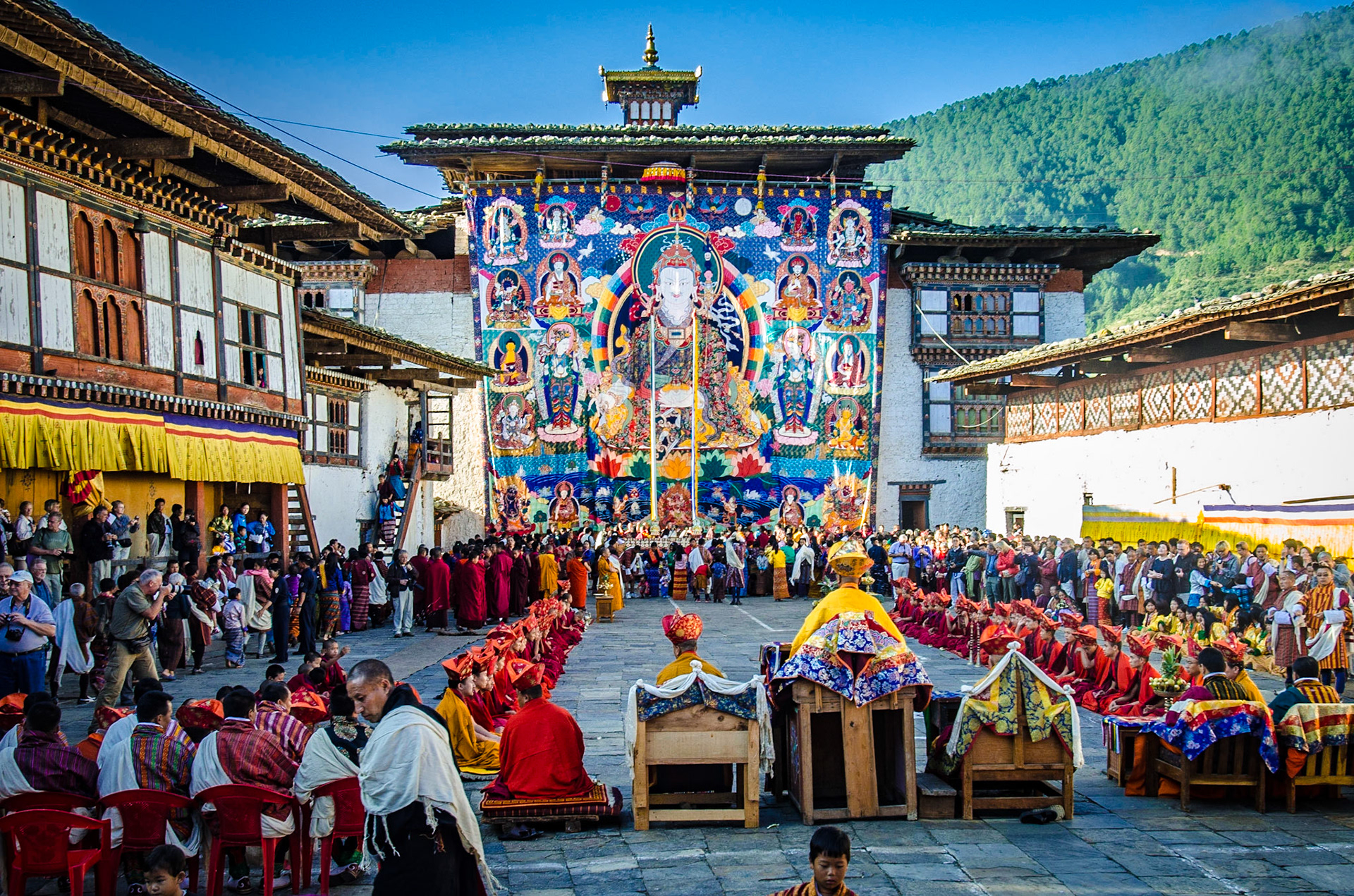 Wangdue Tshechu is a three-day festival of mask and folk dances founded by the 4th Temporal Ruler of Bhutan, Tenzing Rabgye (1638-1696), to commemorate the birth of Guru Padmasambhave. The Tshechu features dance by monks and laymen, and on the final day, before sunrise, the thangka will be unfurled and only shown for a few hours. Thangka, large cotton and silk painted murals, have served through history as important teaching tools depicting the life of the Buddha. The unfurling is marked by intense religious fervor, the large thangka (measuring about 30 meters or 100 ft) is surrounded by devotees who gather to witness this occasion.   The Annual Tshechu was held at Wangdue Dzong, which sadly burned to the ground in June, 2012.Since then it was re-located to the Tencholing Military Training center. Fortunately the reconstruction of Wangdue Dzong has already begun, but will only completed in 2021. see: http://www.indochinatravel.com/country/bhutan/festivals/wangdue-tshechu-2013.html