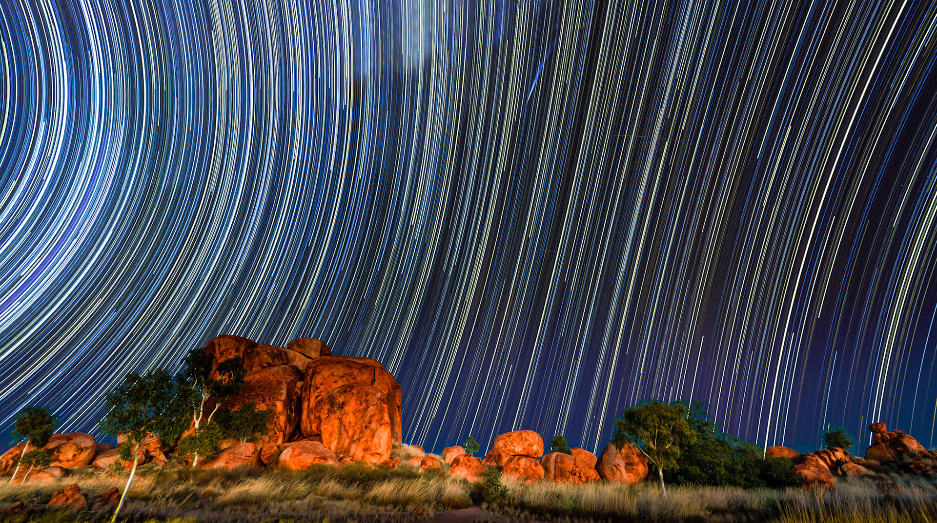 Startrails and Meteor at Devil's Marbels National Park, Northern Territory, Australia. This is a 7 hours star trail exposure during a clear moonless night in the red centre of Australia. In the upper middle of the image you see a meteor