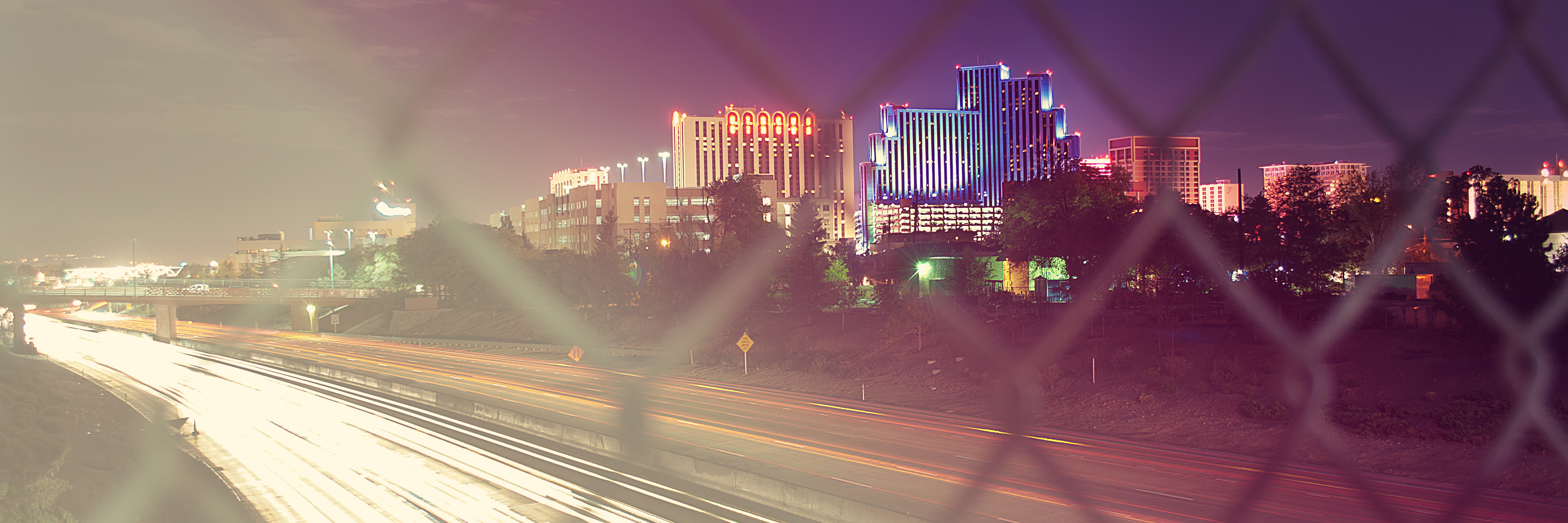 Artistic night view of Reno, Nevada, with I-80 traffic creating light trails among the casinos, representing our local agency.