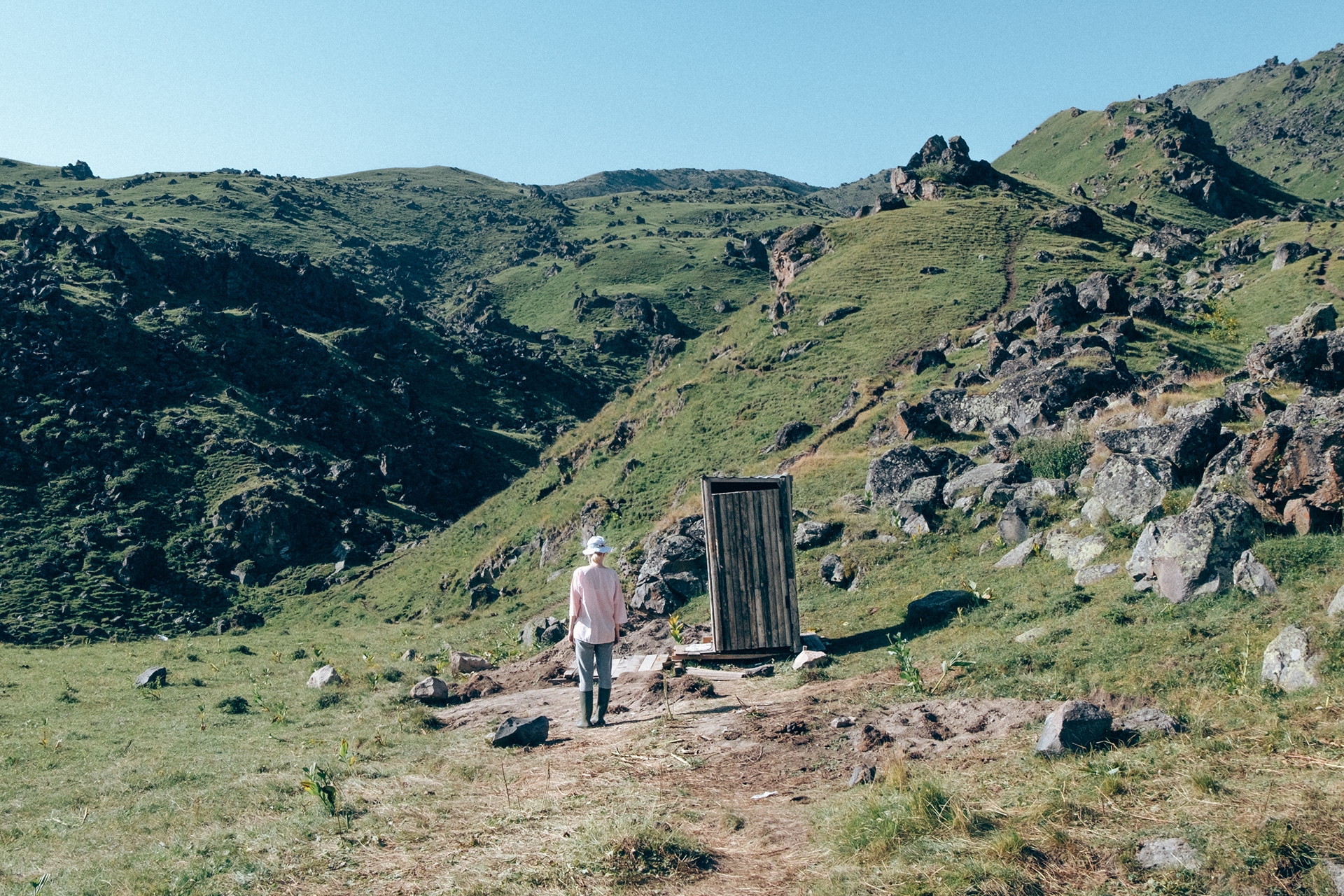 a woman waiting in the emptiness in front of a toilet