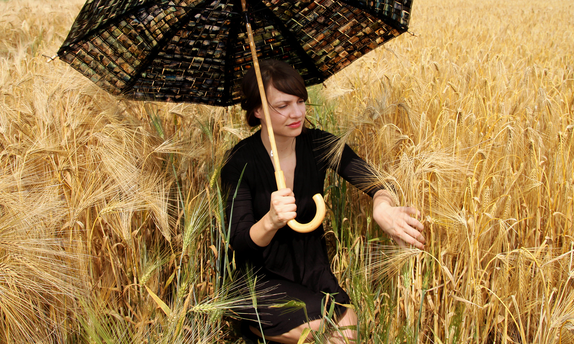 textile art project No. 1: Nadine sitting in a field - umbrella made from old slide film, yarn and tape