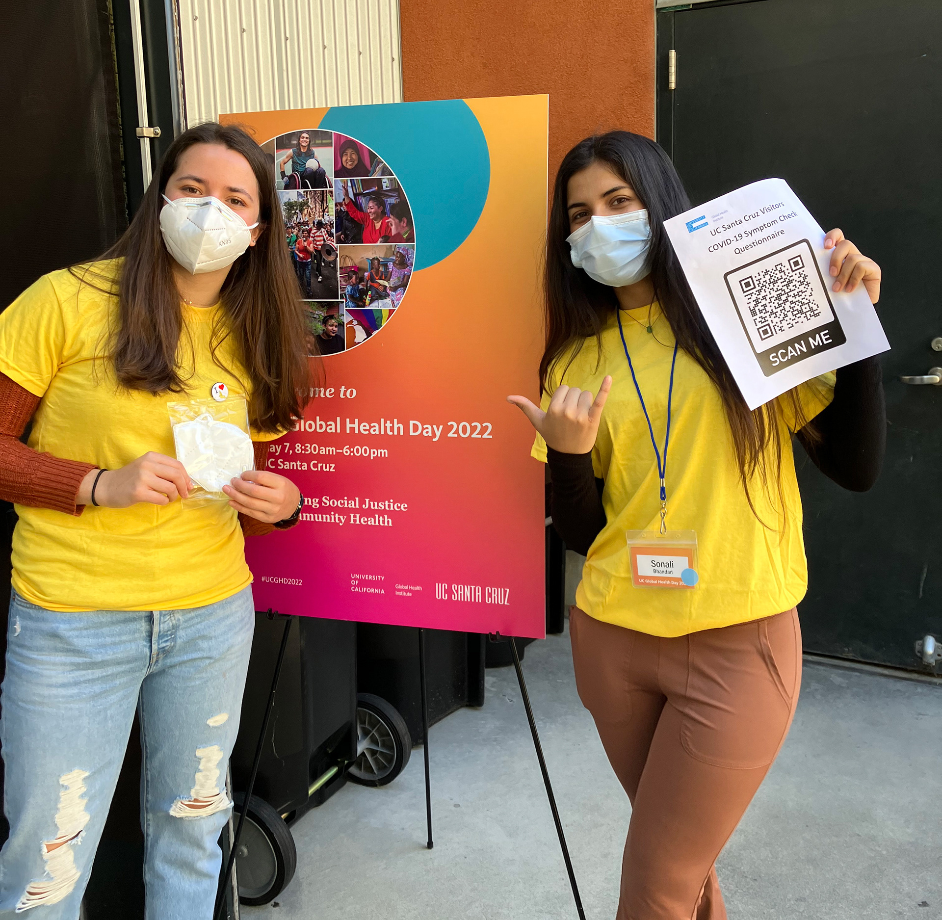 Student volunteers stand in front of welcome poster