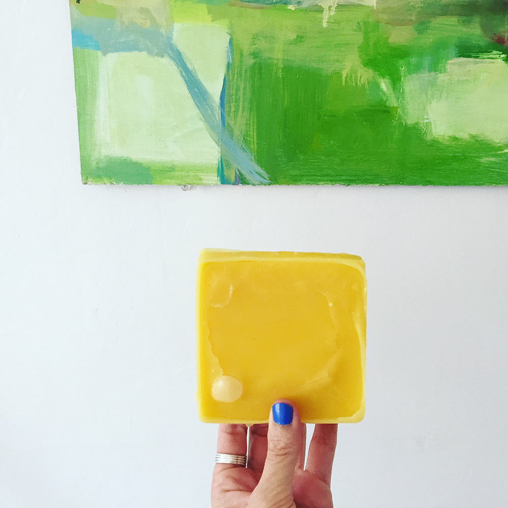 Hand holding a chunk of beeswax.