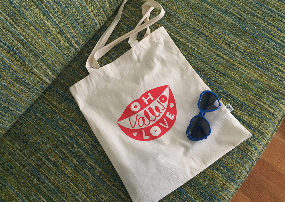 Oh Vallejo Love tote bag on a couch with heart shaped sunglasses