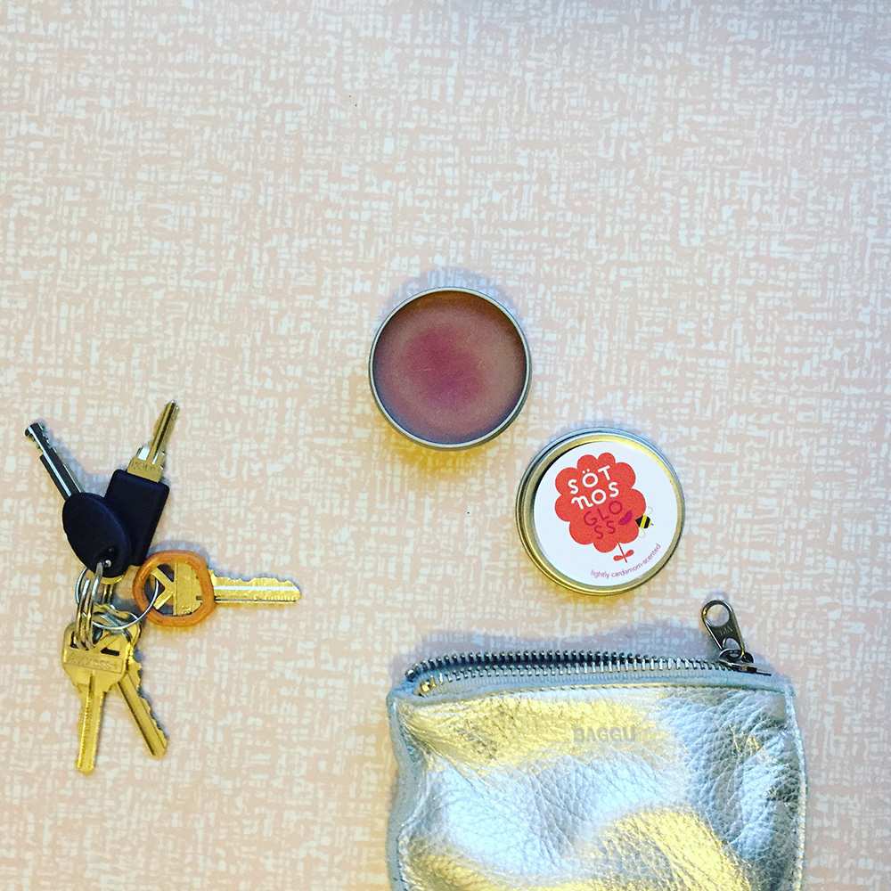 Small gloss tin that says Sötnos Gloss, lightly cardamom-scented.