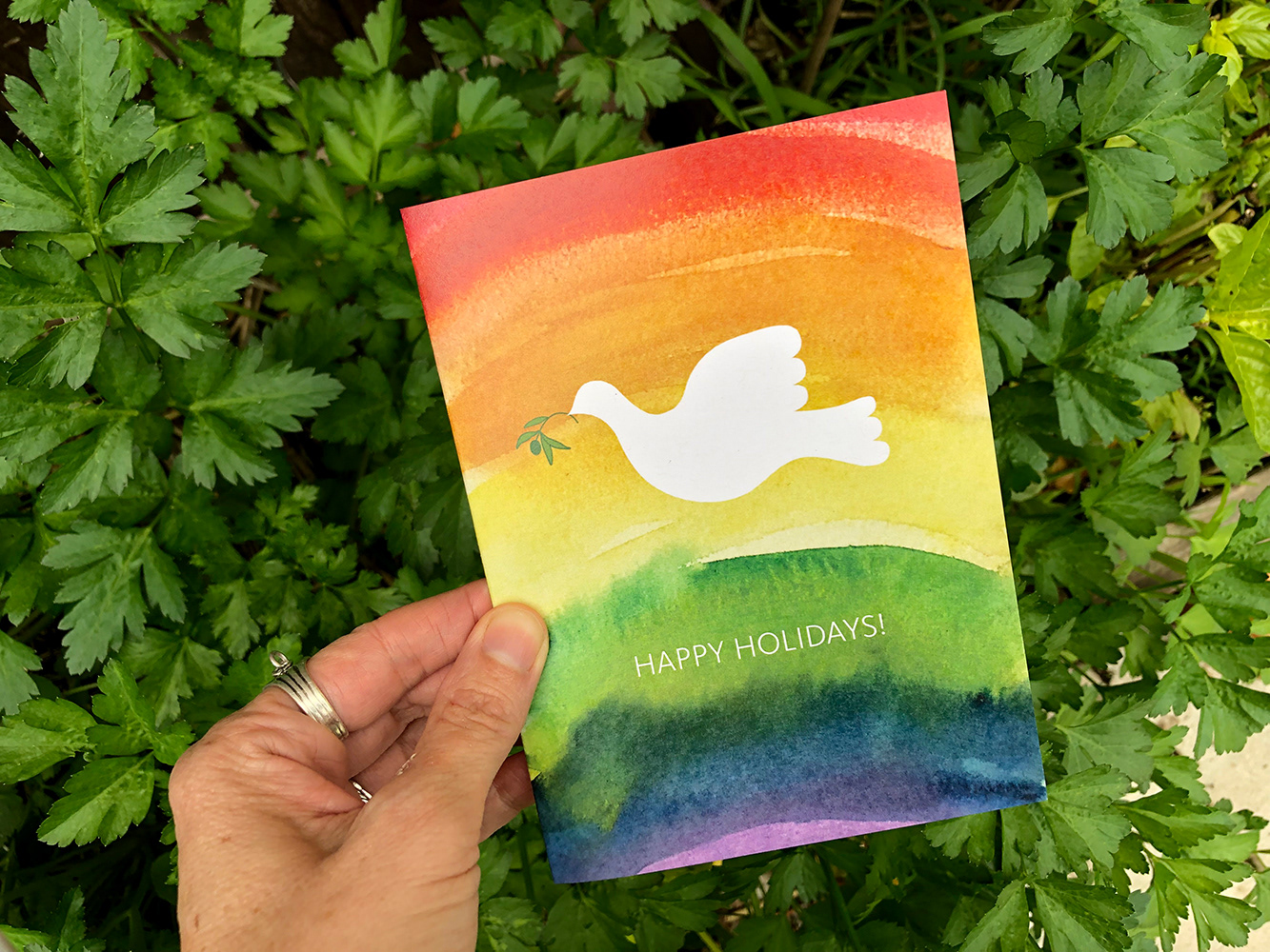 Illustrated white dove flying over a rainbow background