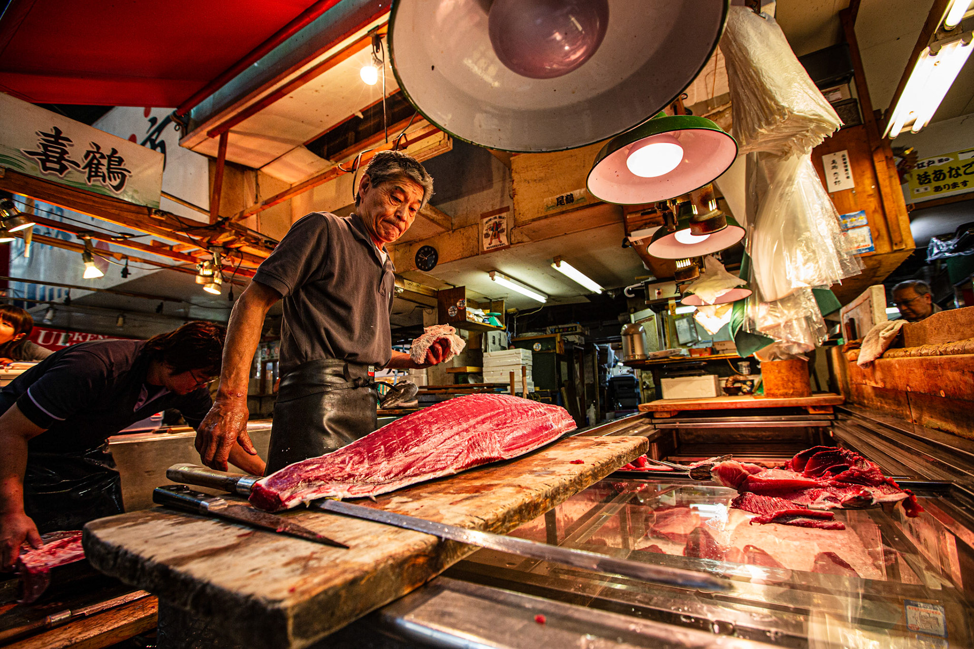 Fishmonger preparing a tuna in Tsukiji Fish Market. Tokyo, Japan