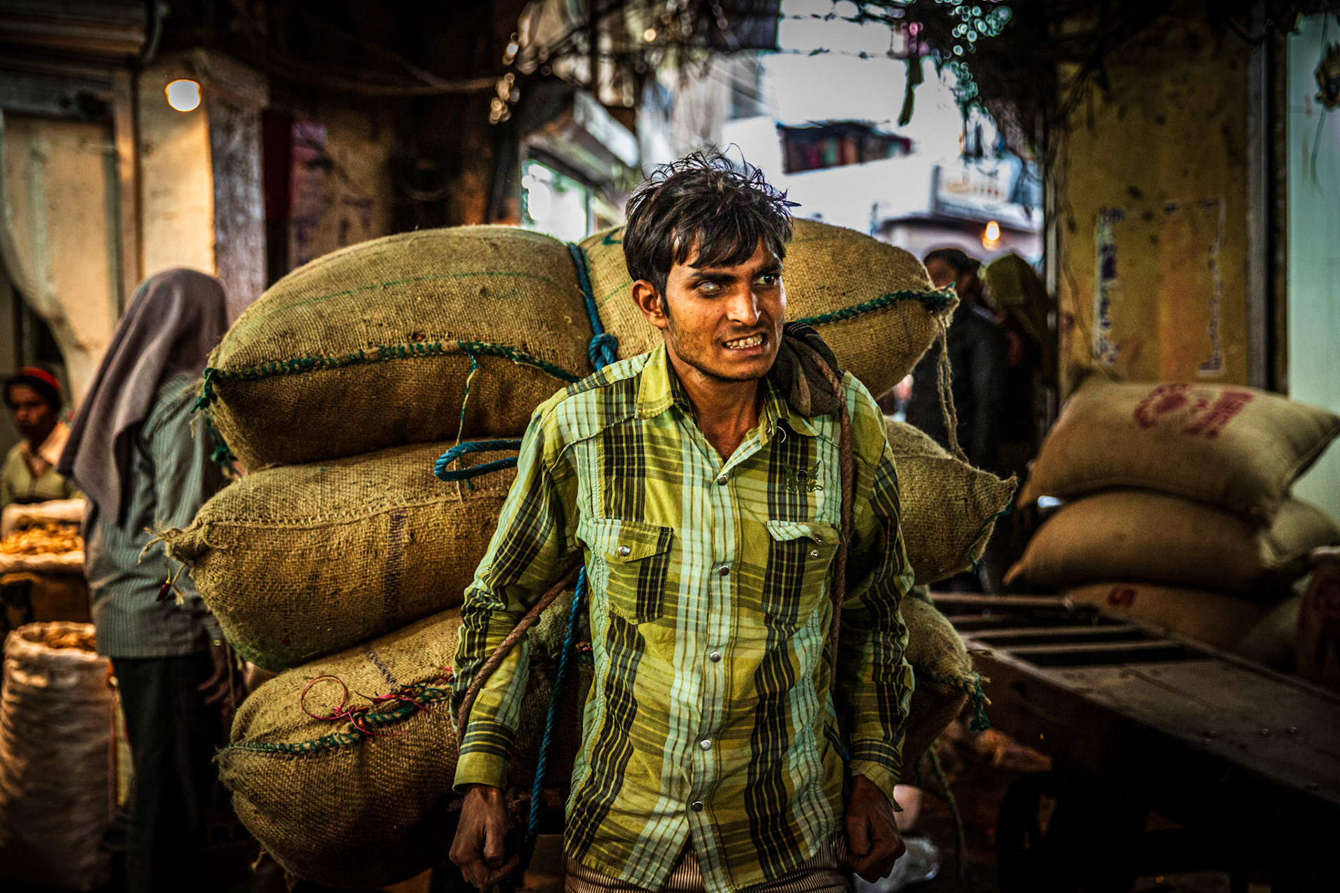 Man carrying a cart full of spices bags. New Delhi, India