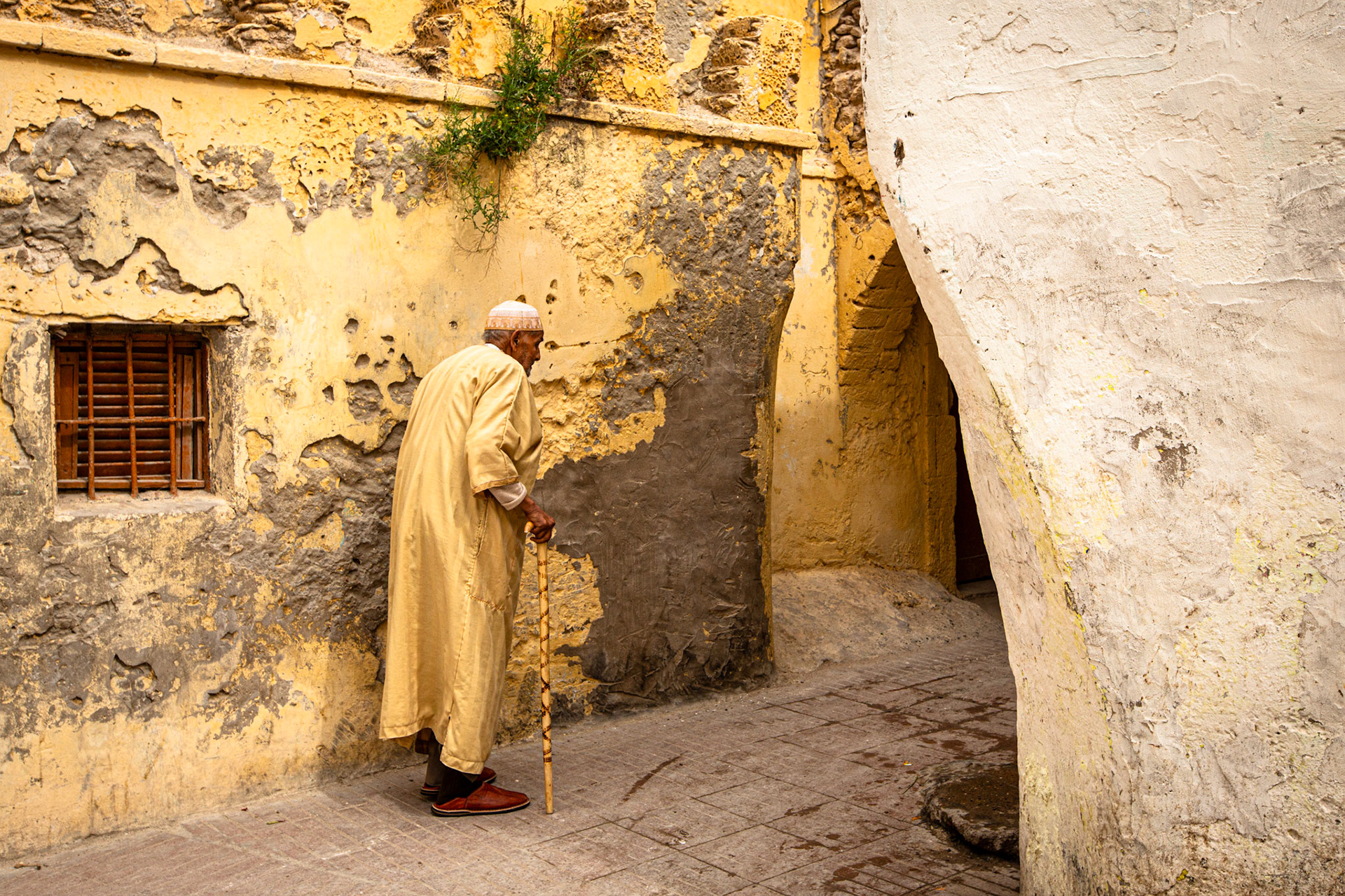 Old man walking in Essaouira medina. Morocco