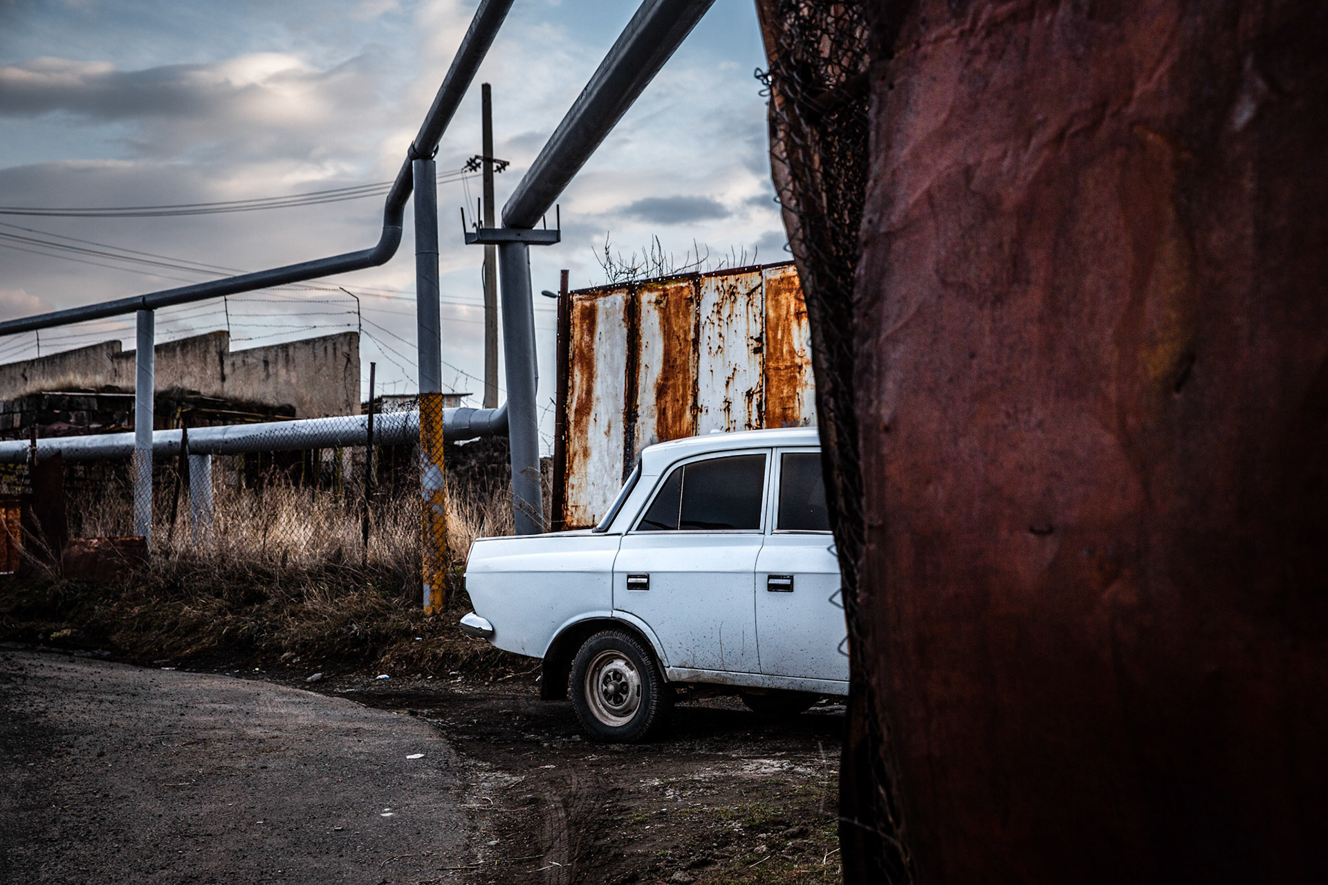 White Lada car below gas pipes in Gyumri. Armenia