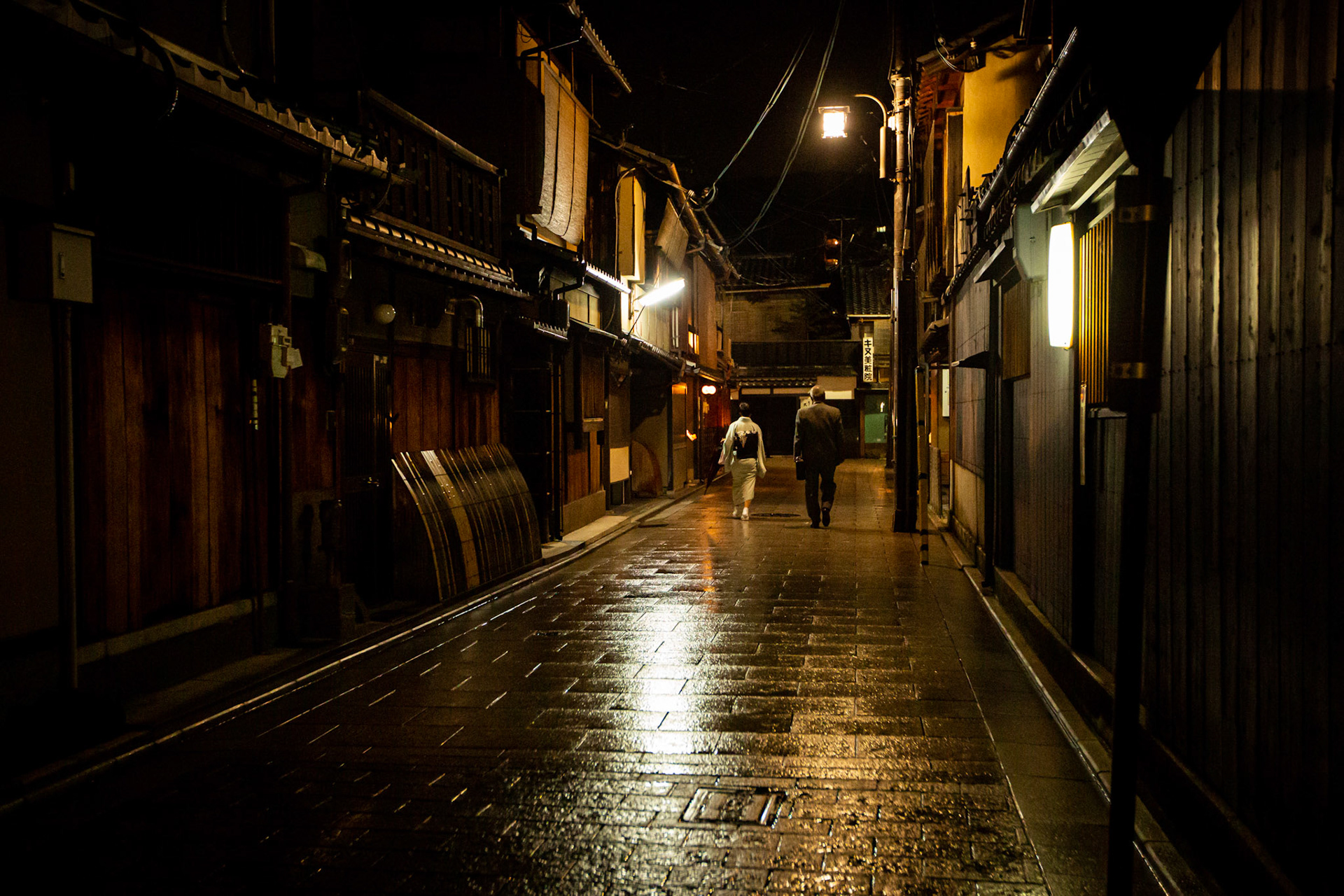 Salary man and woman wearing a kimono walking in Gion. Kyoto, Japan