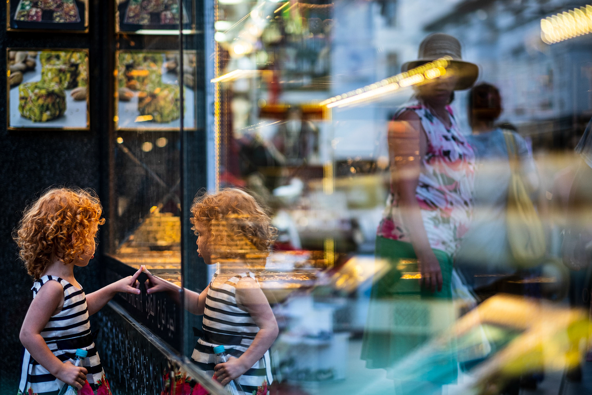 Istanbul, Turkey - 26 August 2019 : Girl pointing to sweets on a shop's window