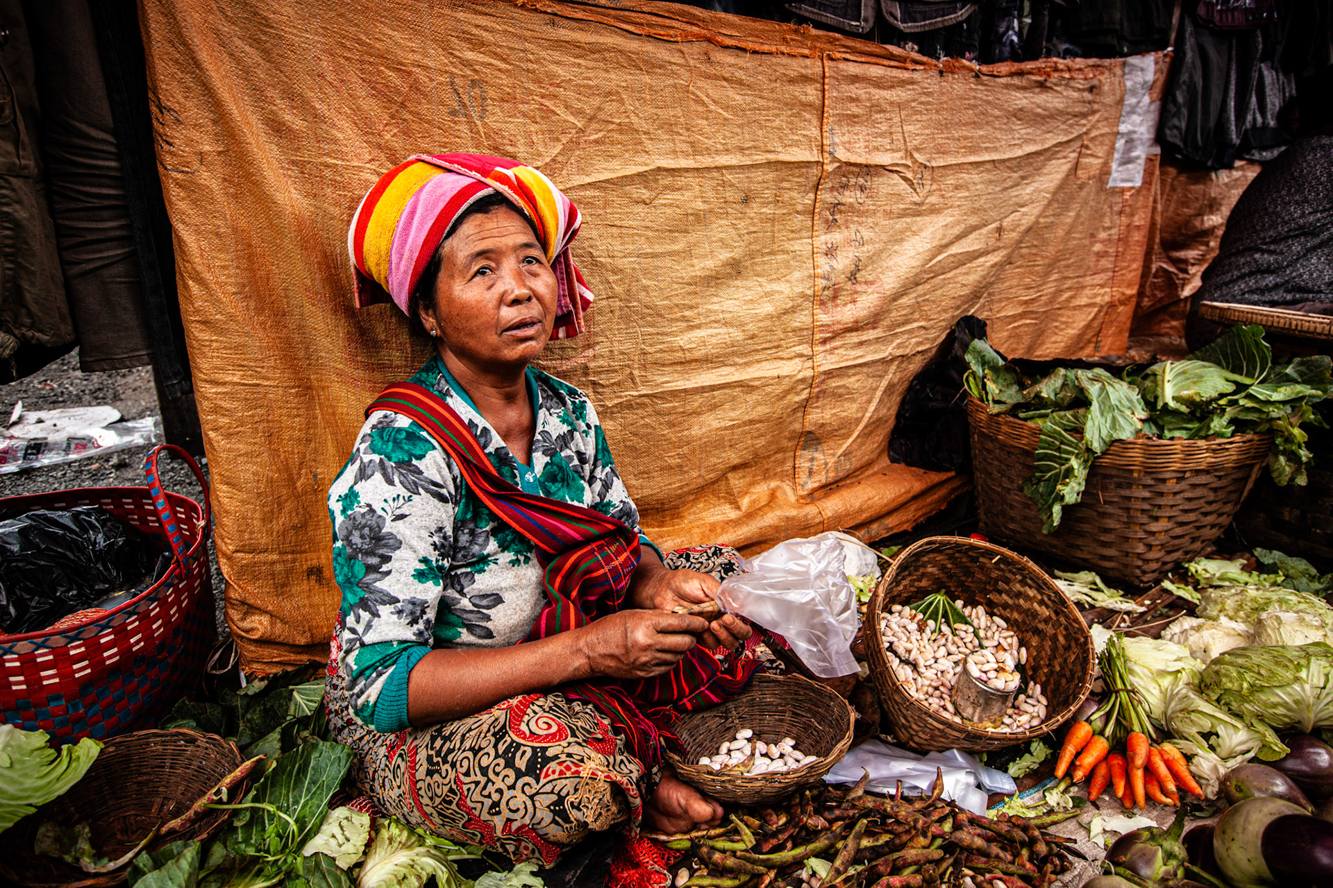 Woman preparing a bunch of carrots at Nyaung Shwe Market. Myanmar