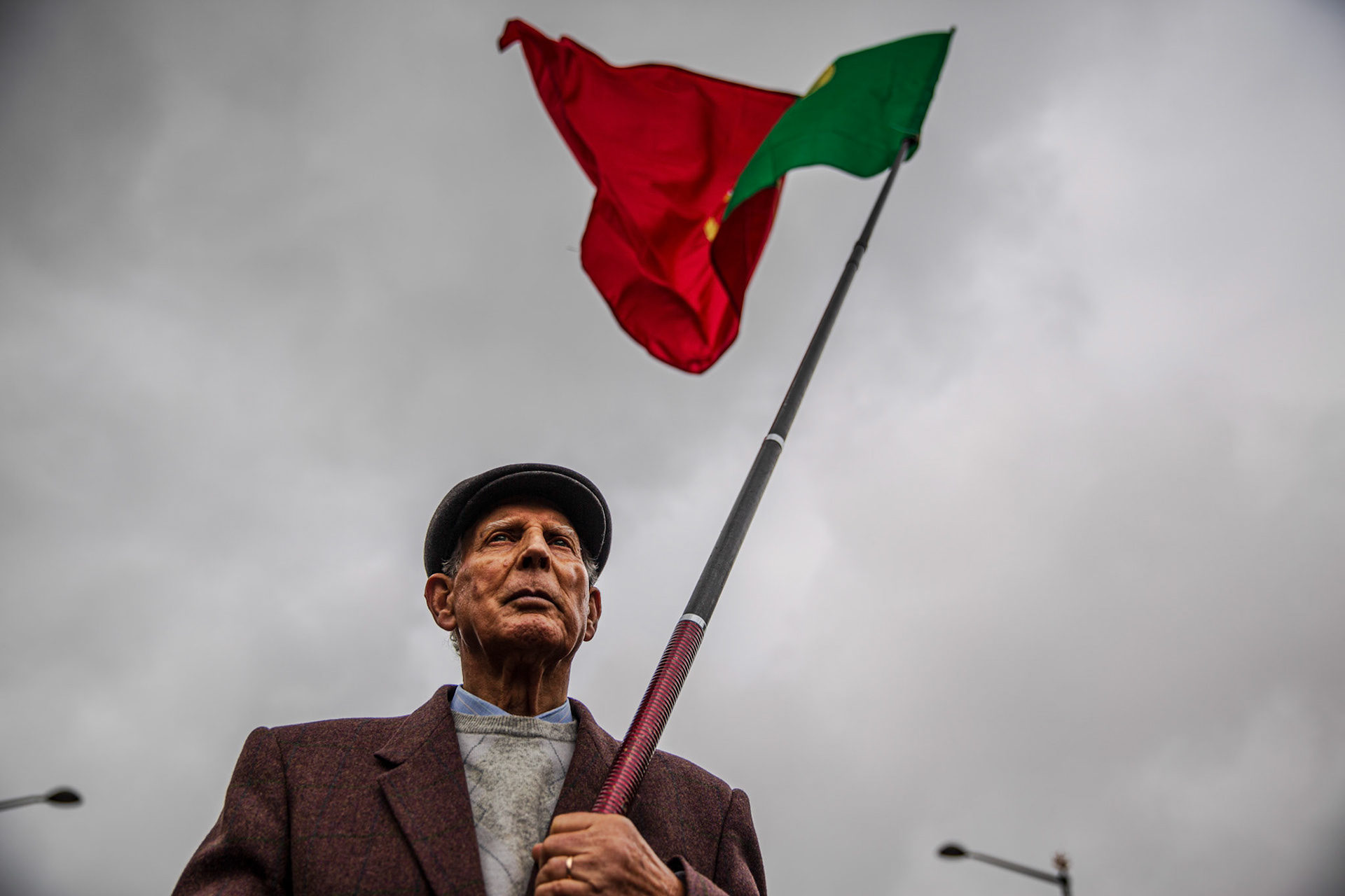 Man holding the Portuguese flag during 25th of April rally. Lisbon, Portugal