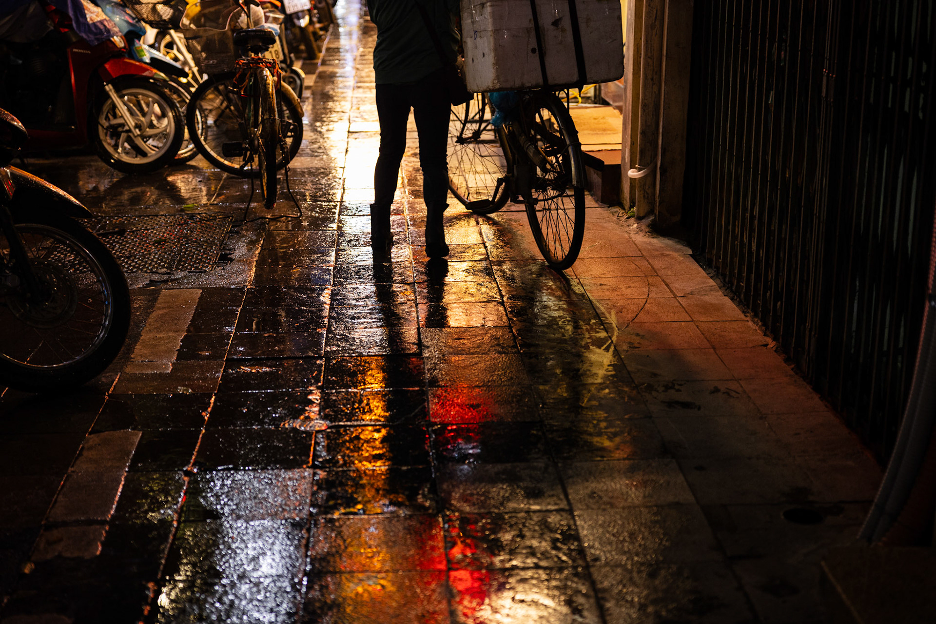 Hanoi, Vietnam - 30 July 2024 : Sidewalk reflections by night