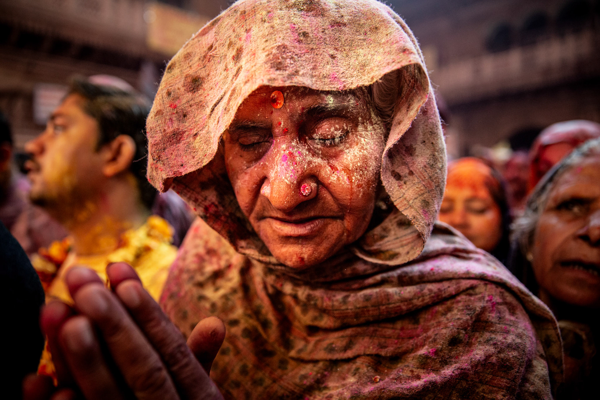 Women praying inside Bankey Bihari temple during Holi celebrations. Vrindavan, India