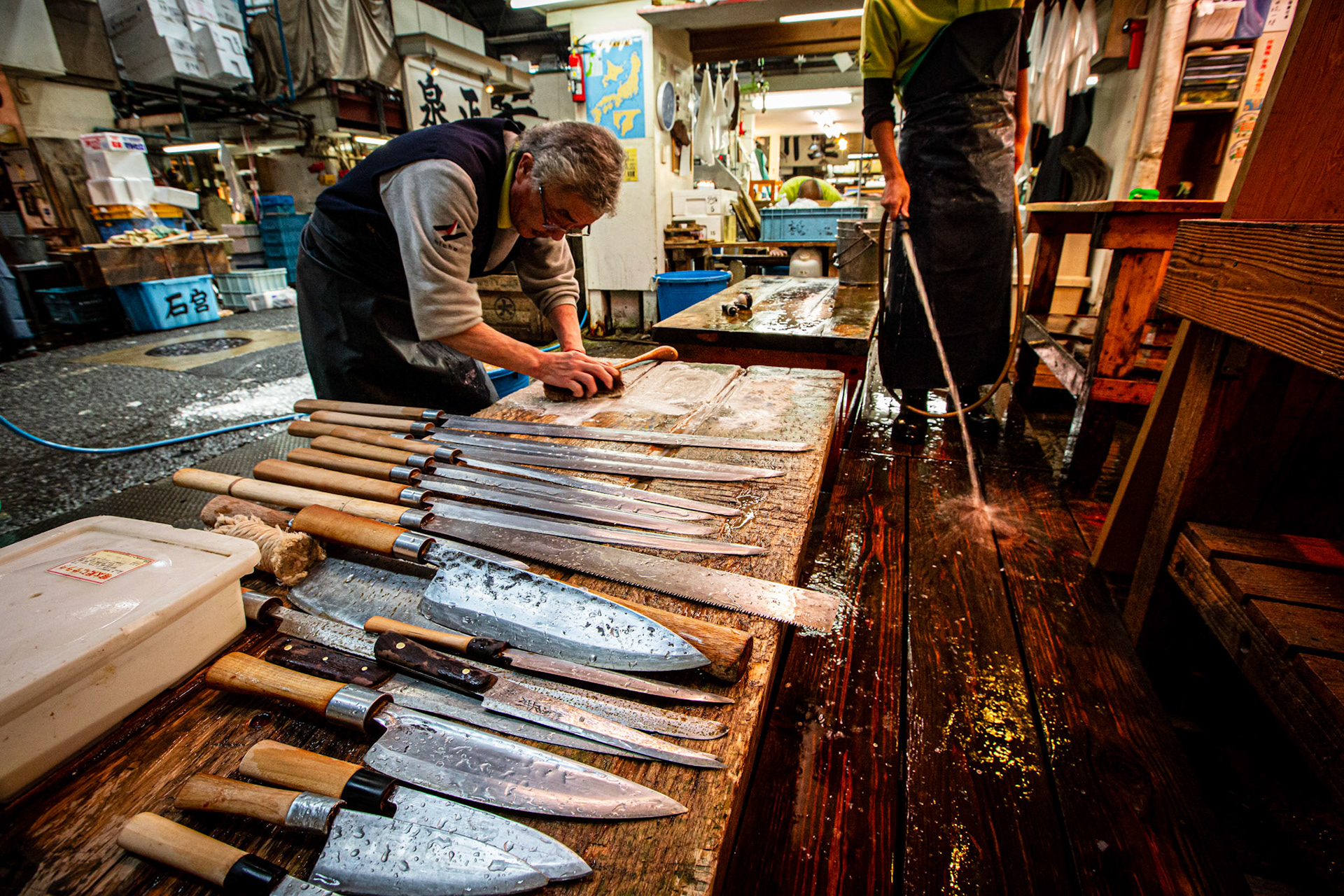 Fishmonger cleaning his knives in Tsukiji Fish Market. Tokyo, Japan