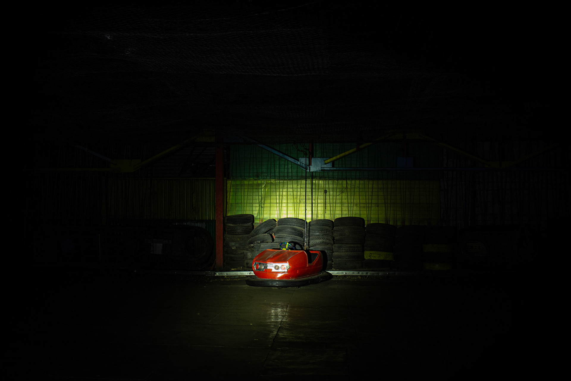 Abandoned red bumper car in Gyumri park at night. Armenia