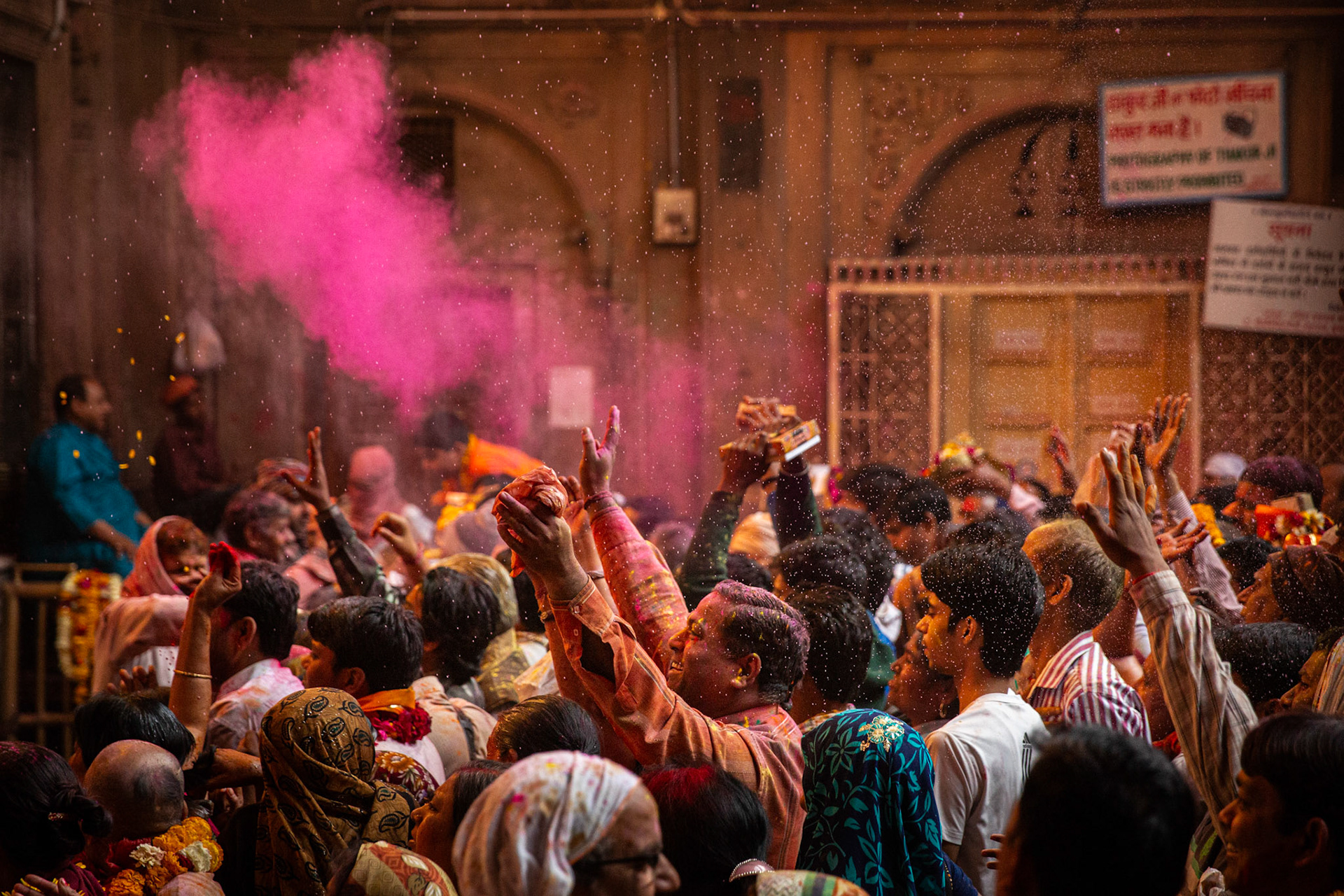 Gulal being thrown inside Bankey Bihari temple during Holi celebrations. Vrindavan, India
