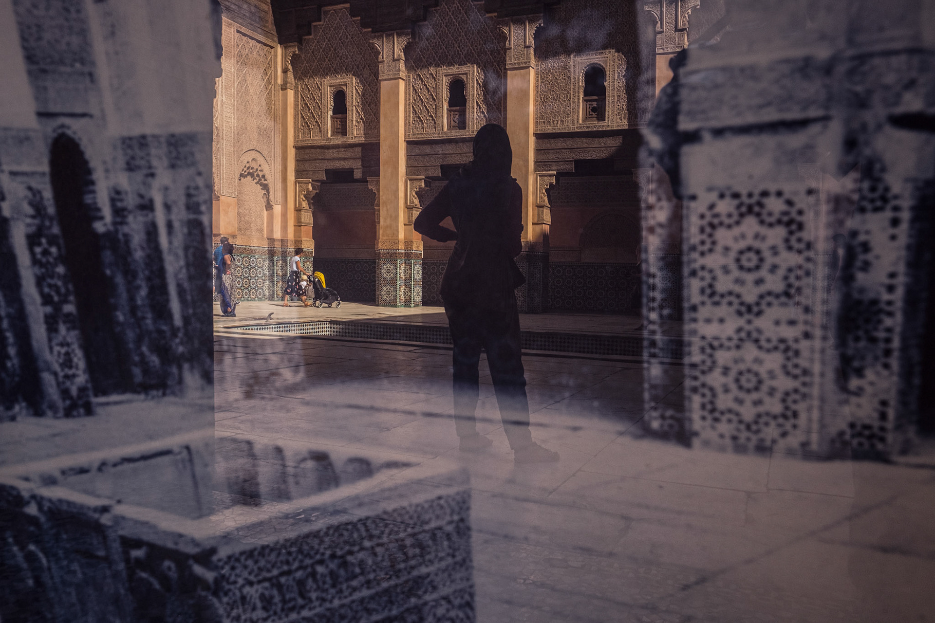 Marrakech, Morocco - 18 September 2017: Reflection of Ben Youssef Madrasa on a photograph of it dating from 1920