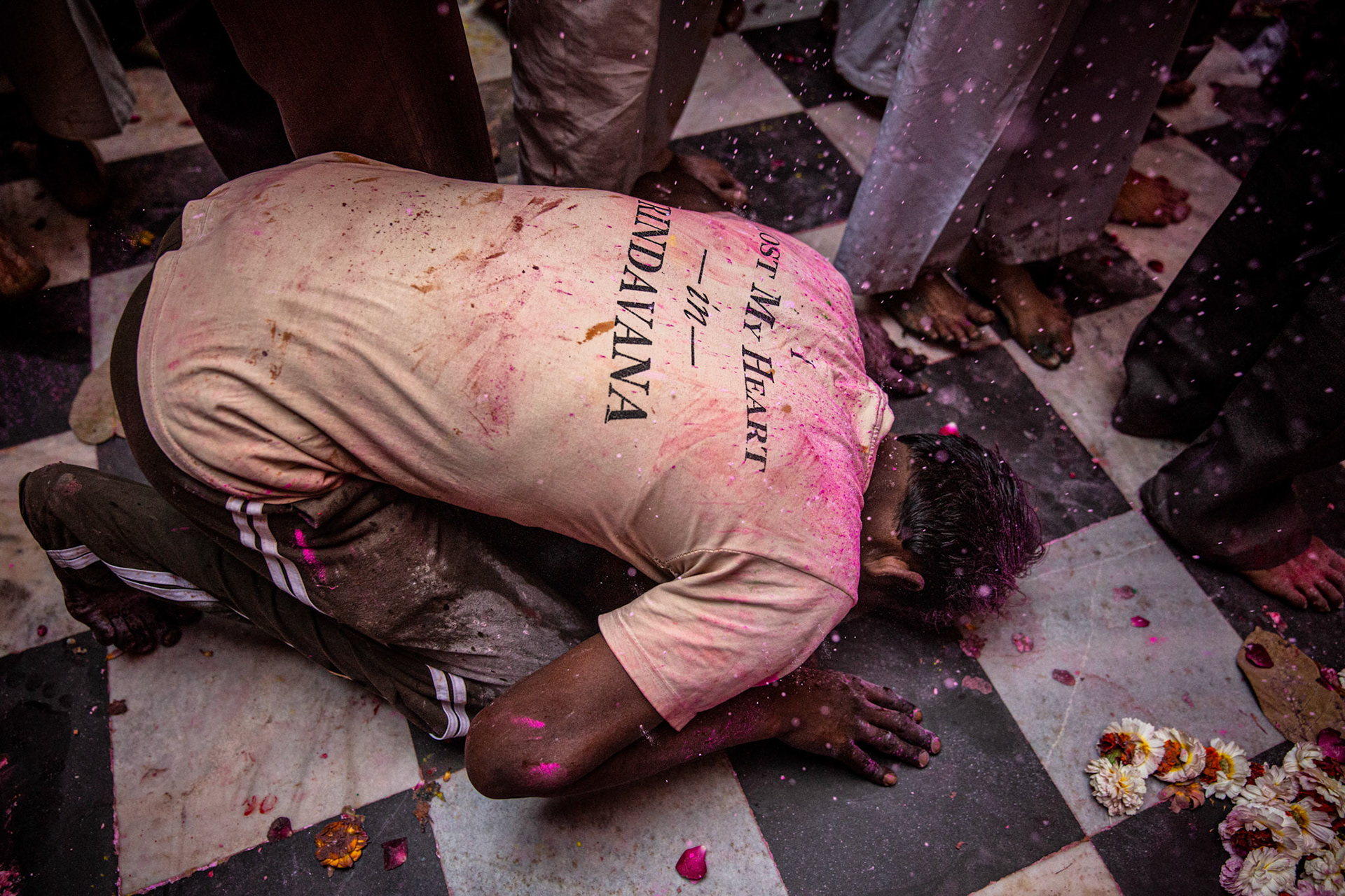 Man kneeling on the floor of Bankey Bihari temple. Vrindavan, India