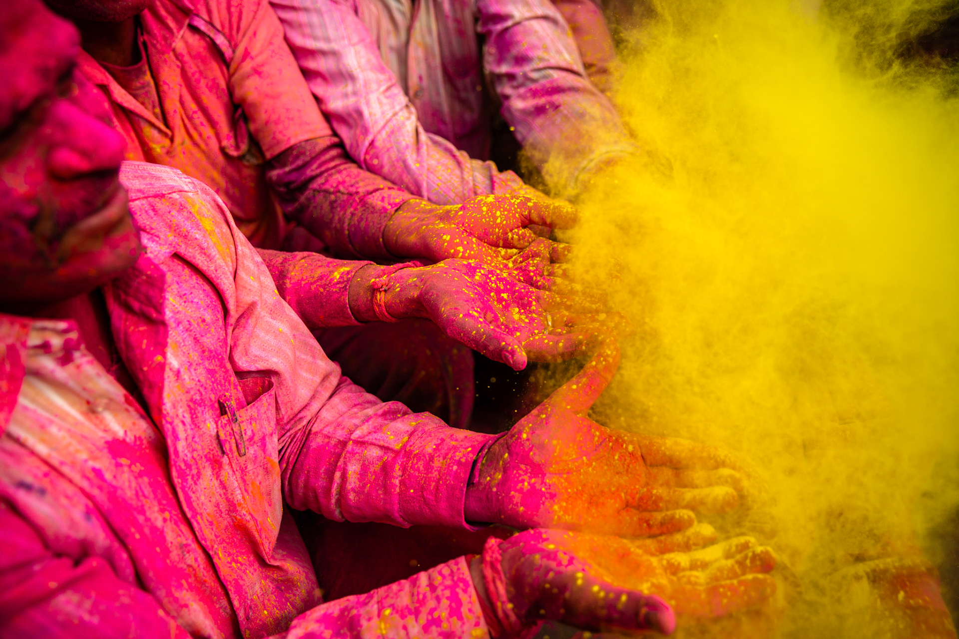 Throwing gulal over men's hands during Nandgaon Holi. India