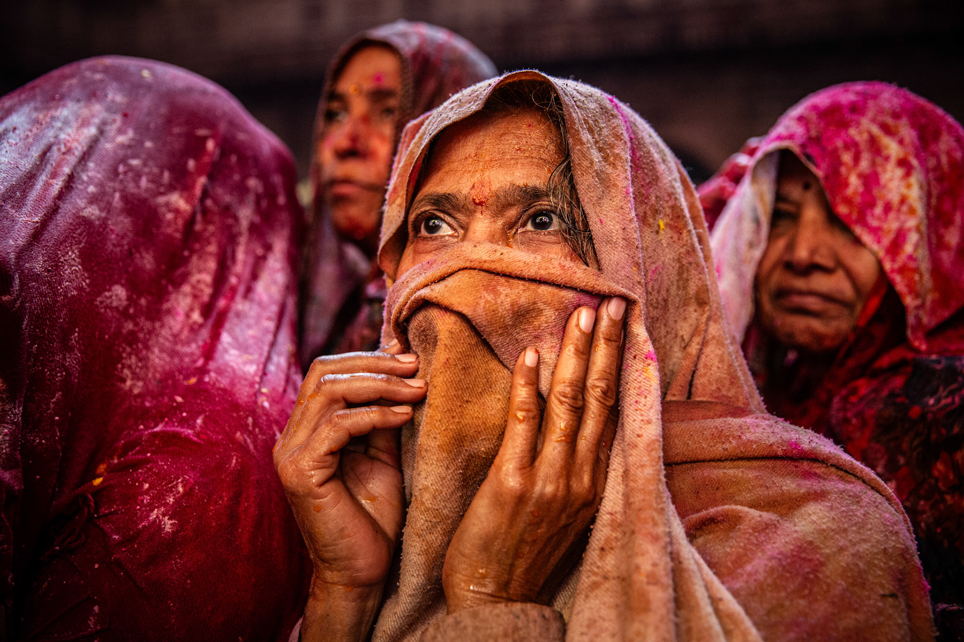 Woman covering her face attending Holi celebrations inside Bankey Bihari temple. Vrindavan, India