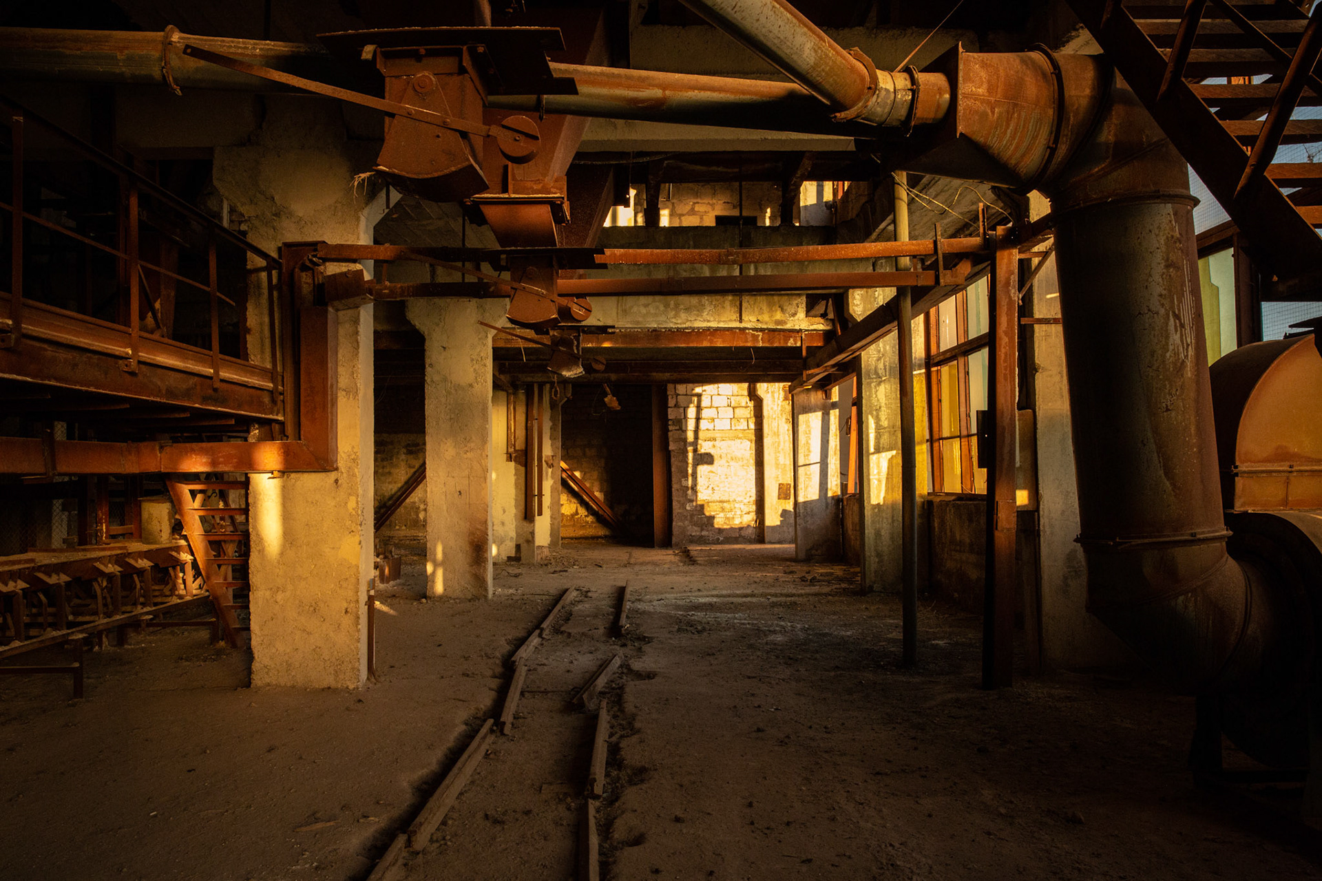 Machines and an abandoned carriage track in an old soviet era glass factory. Gyumri, Armenia
