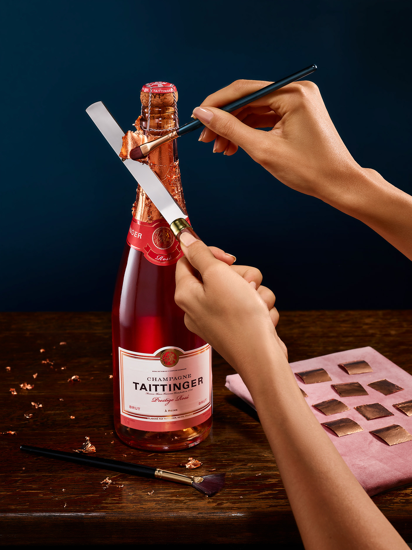 Taittinger, PALAST - still life photography, hand model, a bottle is getting a gold finish by hand with golden leaf and a brush,  Paris France