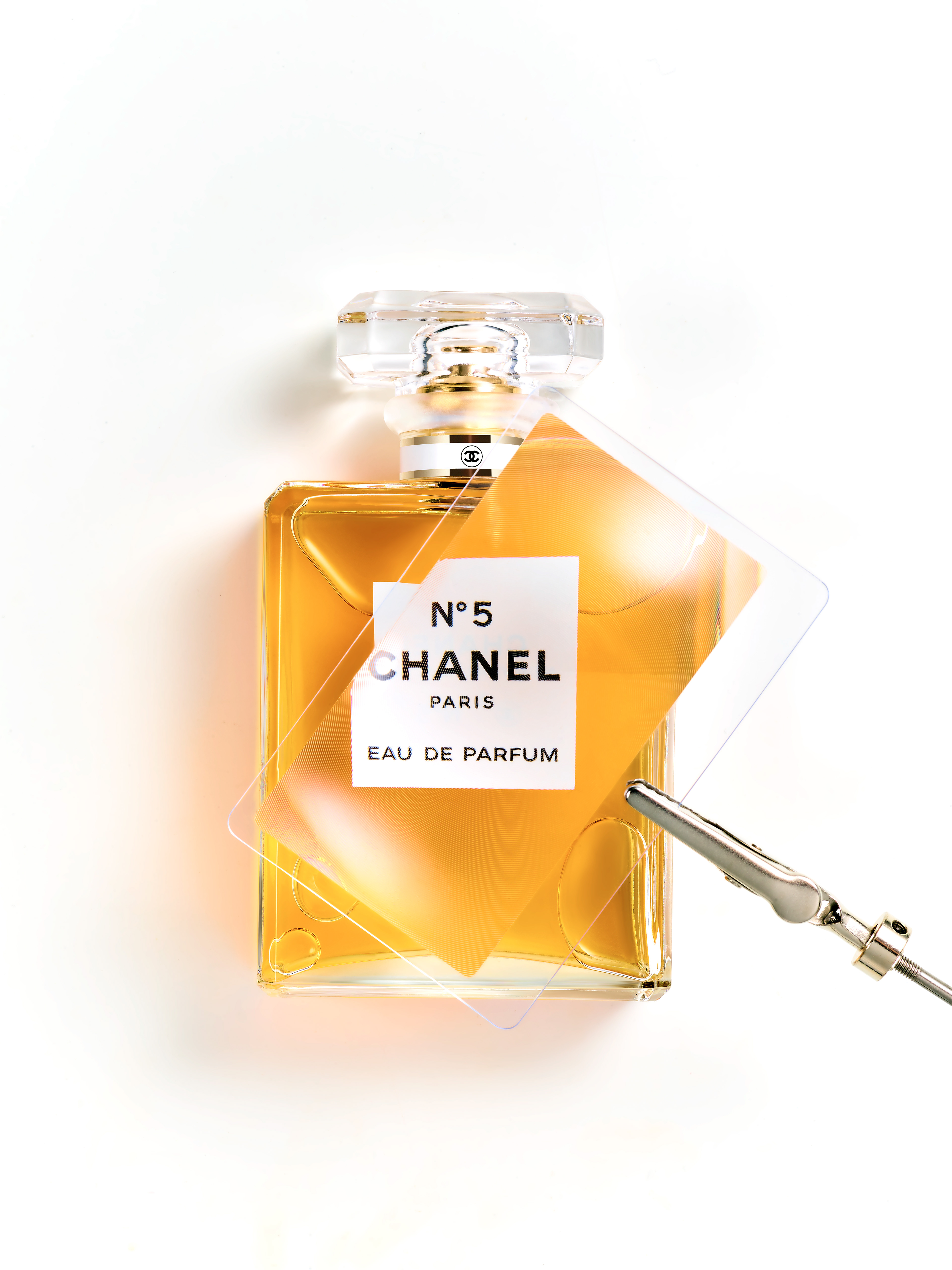 Chanel Parfums : Chanel N°5, photographie de nature morte, parfum, photographie d'un flacon sur fond blanc avec une loupe Fresnel- PALAST PHOTOGRAPHIE, Paris France
