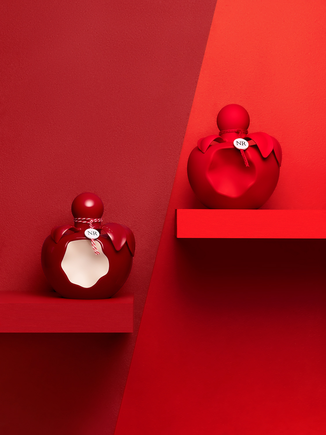 Nina Ricci Parfums : Nina extra rouge, photographie de nature morte, parfum, photographie de flacons Nina Ricci sur fond rouge, color bock - PALAST PHOTOGRAPHIE, Paris France