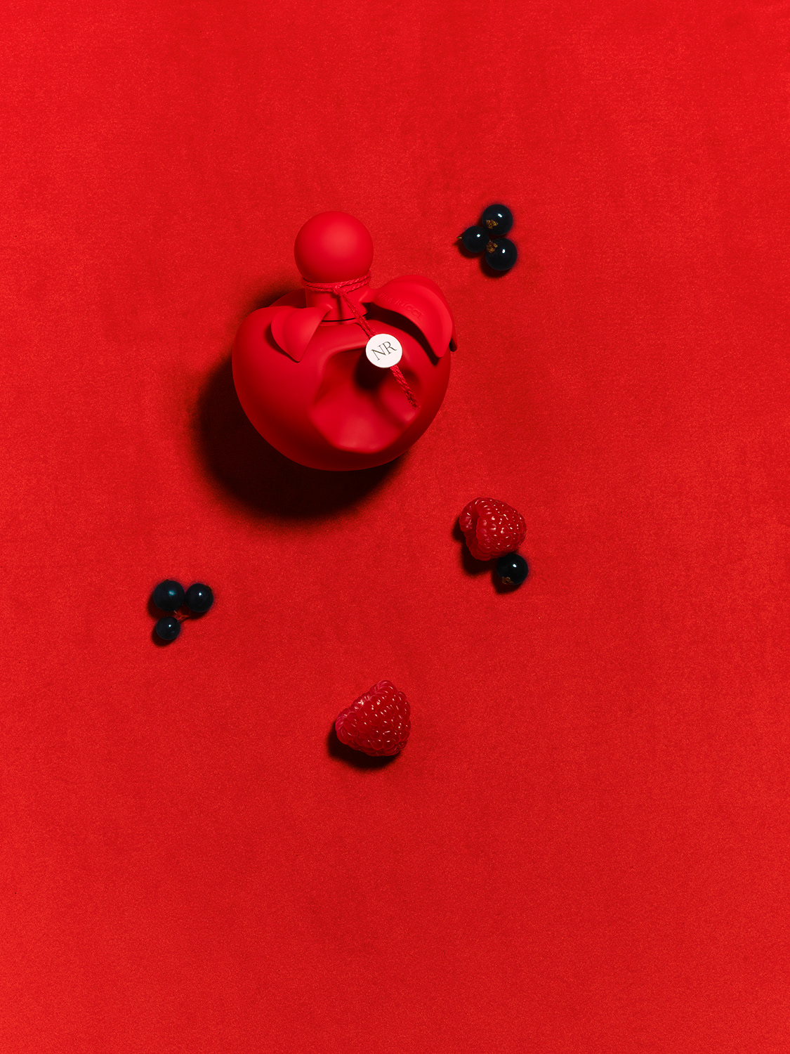Nina Ricci Parfums : Nina extra rouge, photographie de nature morte, parfum, photographie des flacons Nina Ricci sur un fond de velours rouge - PALAST PHOTOGRAPHIE, Paris France