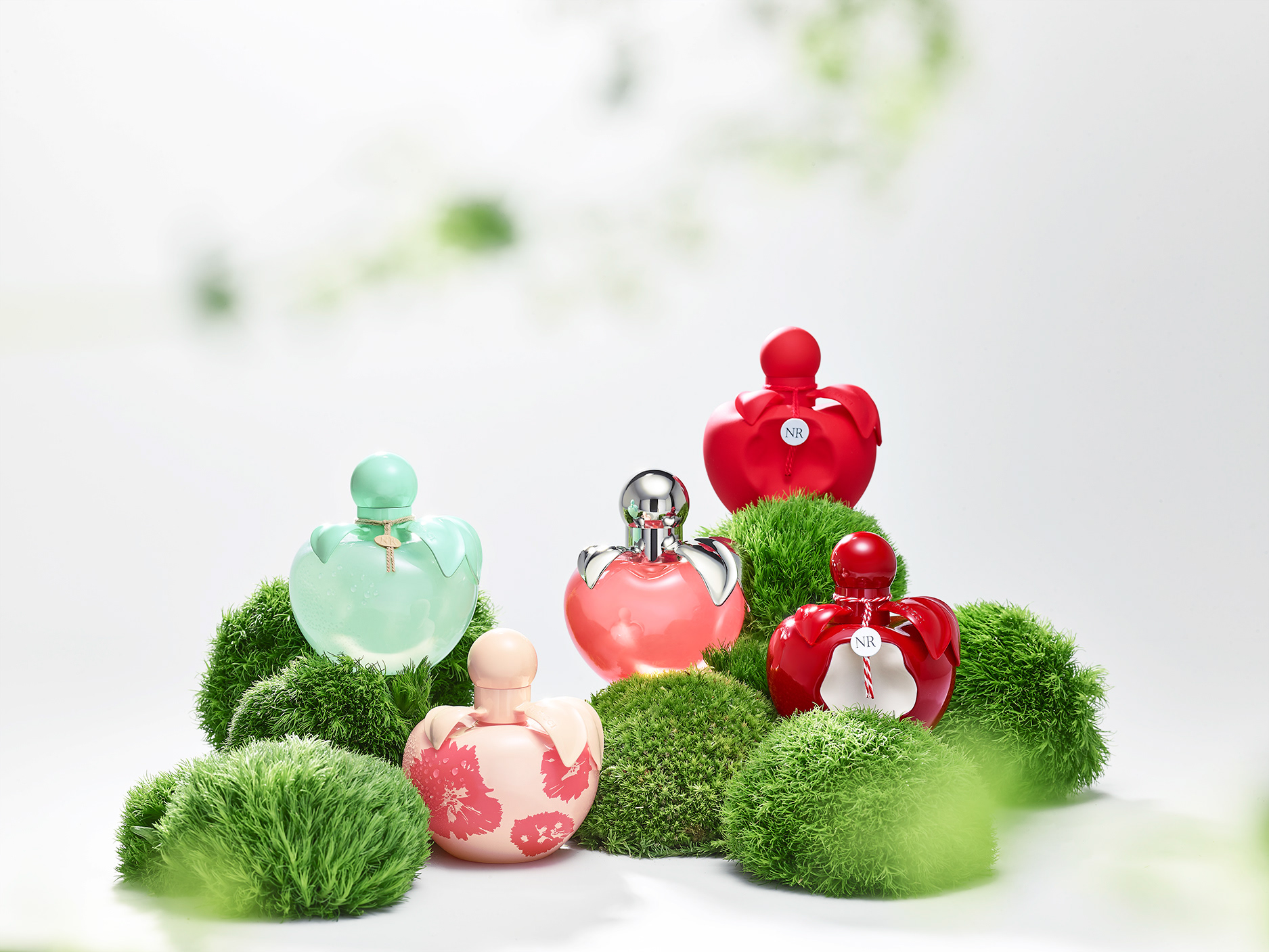 Nina Ricci Parfums : Nina Nature, photographie de nature morte, parfum, photographie d'un flacon Nina Ricci entouré de plantes et fleurs - PALAST PHOTOGRAPHIE, Paris France