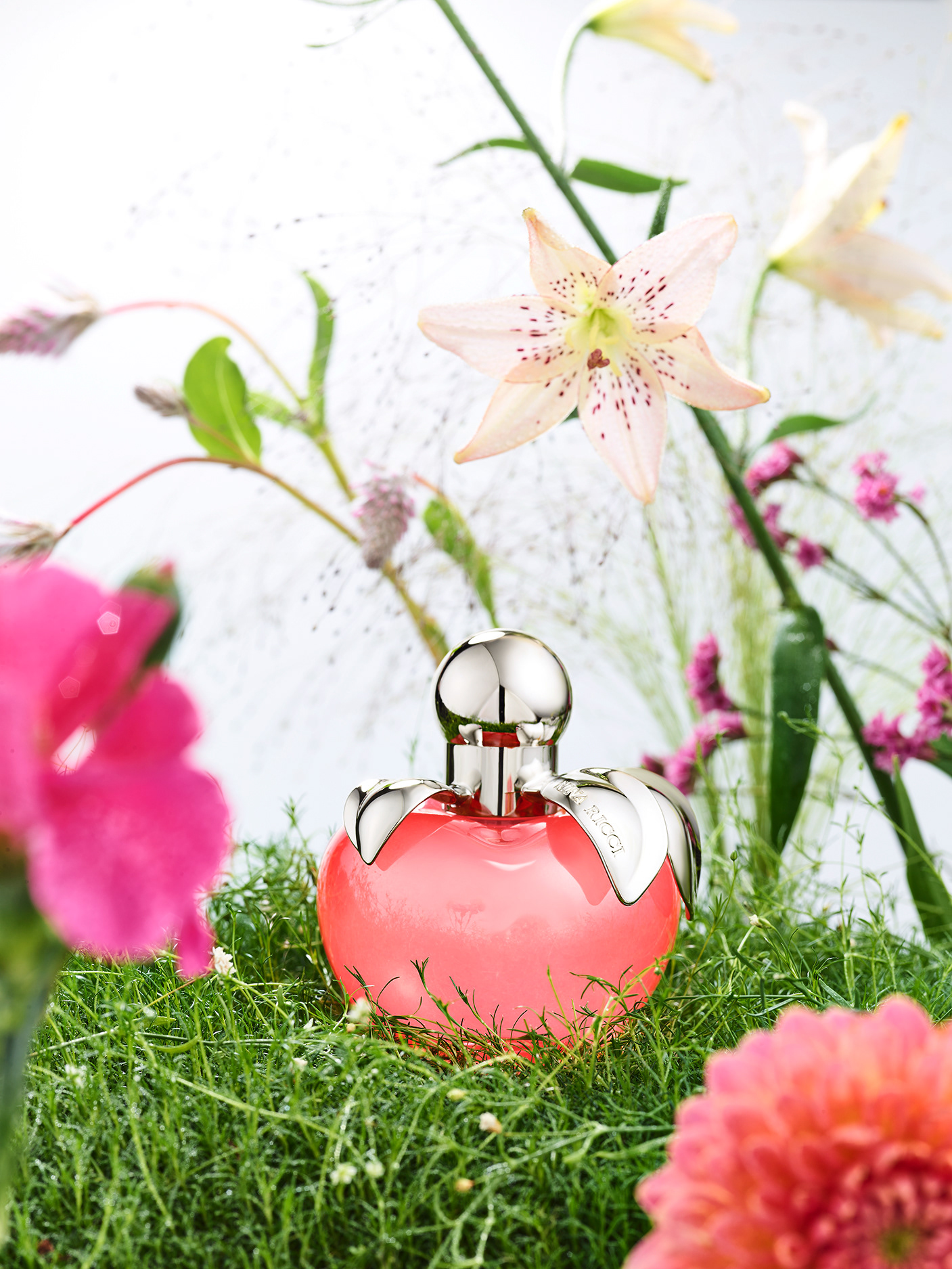 Nina Ricci Parfums : Nina Nature, photographie de nature morte, parfum, photographie d'un flacon Nina Ricci entouré de plantes et fleurs - PALAST PHOTOGRAPHIE, Paris France