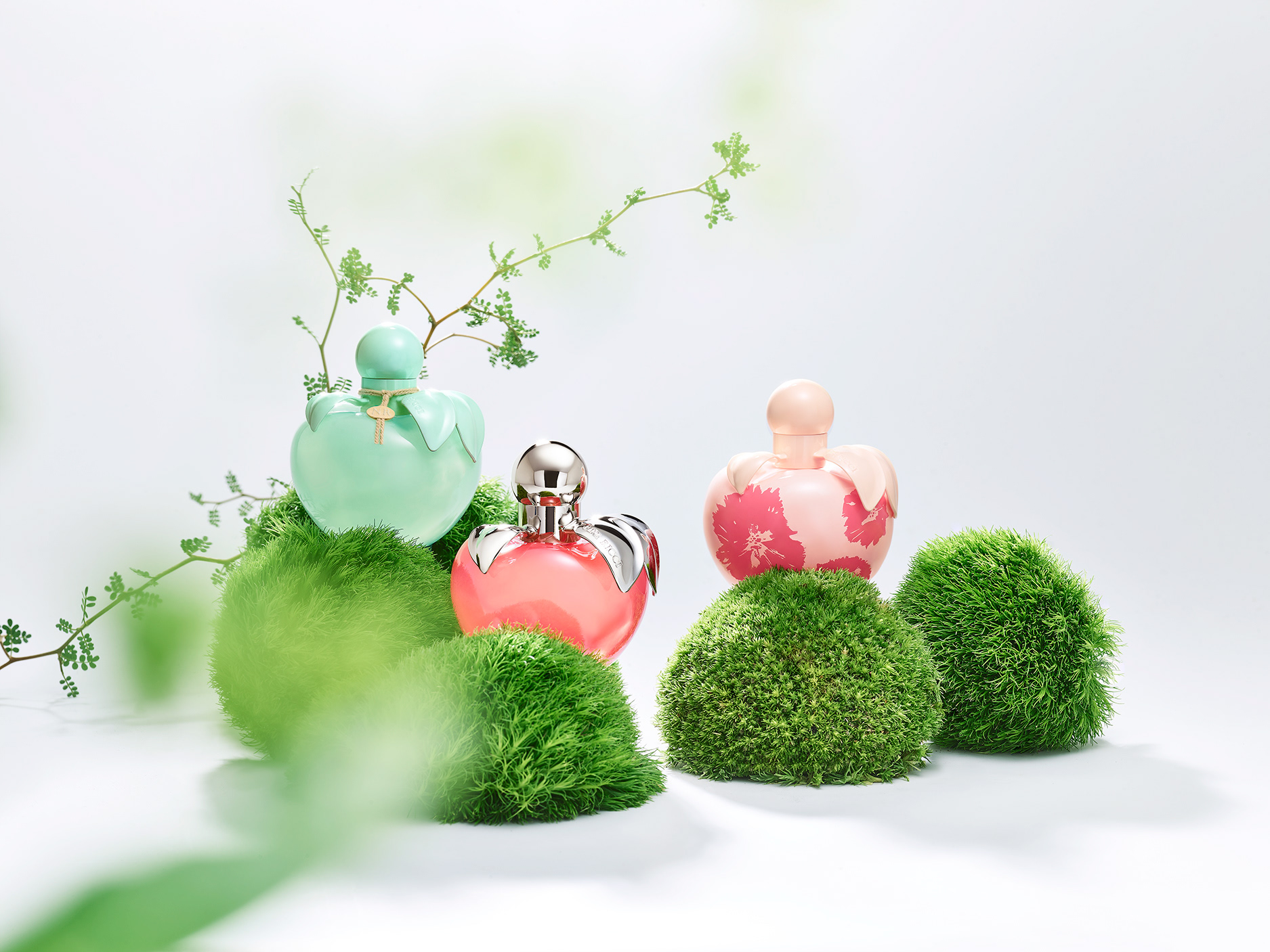 Nina Ricci Parfums : Nina Nature, photographie de nature morte, parfum, photographie d'un flacon Nina Nature, Nina Classic et Nina Flower, entourés de plantes et fleurs - PALAST PHOTOGRAPHIE, Paris France
