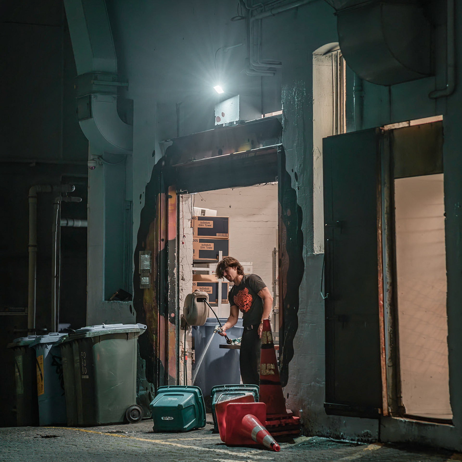 Hospo worker cleaning up in the back alley behind burger liquor on Willis Street