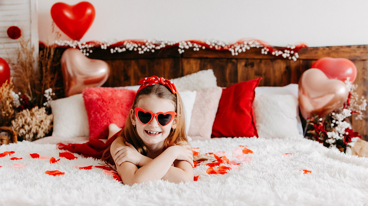 Holčička se srdíčkovými brýlemi na valentýnském pozadí se srdíčky