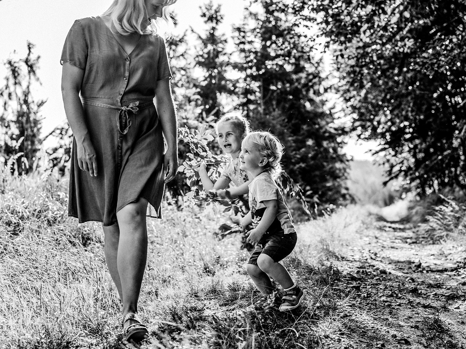 děti honící maminku na cestě v lese při focení