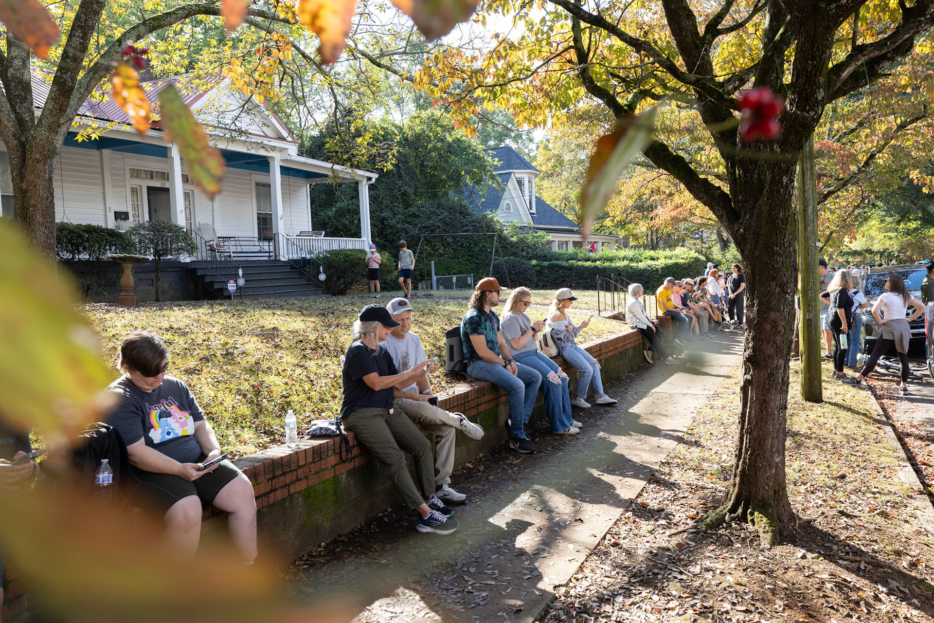Attendees relax on a historic home’s wall during Porchfest in Athens, Georgia on Sunday, Oct. 19, 2025. (Photo/Evan Frilingos)