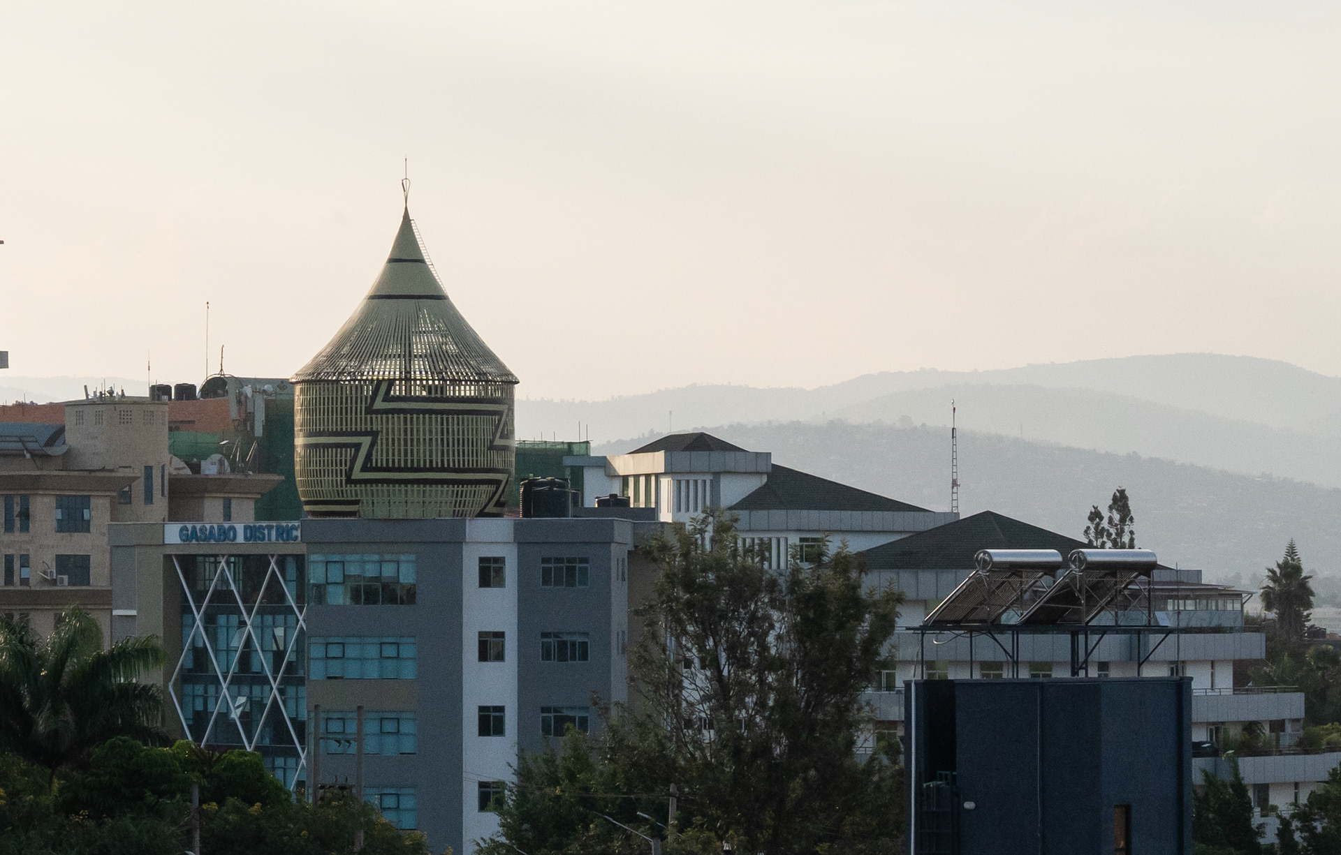 A large structure resembling a peace basket sits atop a high-rise on Wednesday, May 27, 2026 in Kigali, Rwanda.   Afrofuturism re-imagines science fiction and the future with African aesthetics, culture and society at the center. It is often found in works of fiction, such as Ryan Coogler’s fictional city Wakanda and film “Black Panther.”   But Kigali is bringing Afrofuturism to life through infrastructure like the Amahoro Stadium, this basket and the Kigali Convention Center, Africa’s most expensive building designed to resemble the former royal palaces. (Photo/Evan Frilingos 2026)
