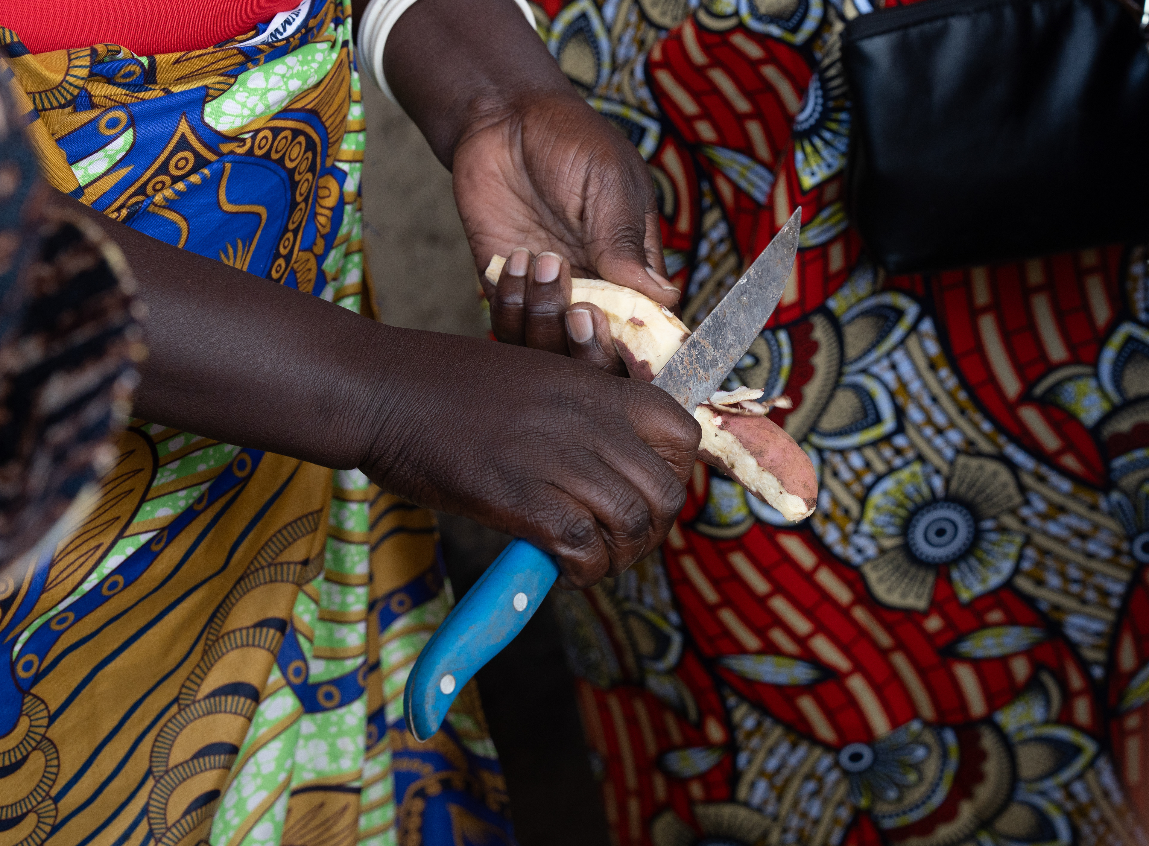 A woman peels sweet potato to prepare a vegetable meal at a rural home on Sunday, May 24, 2026 in Karama, Rwanda. (Photo/Evan Frilingos)