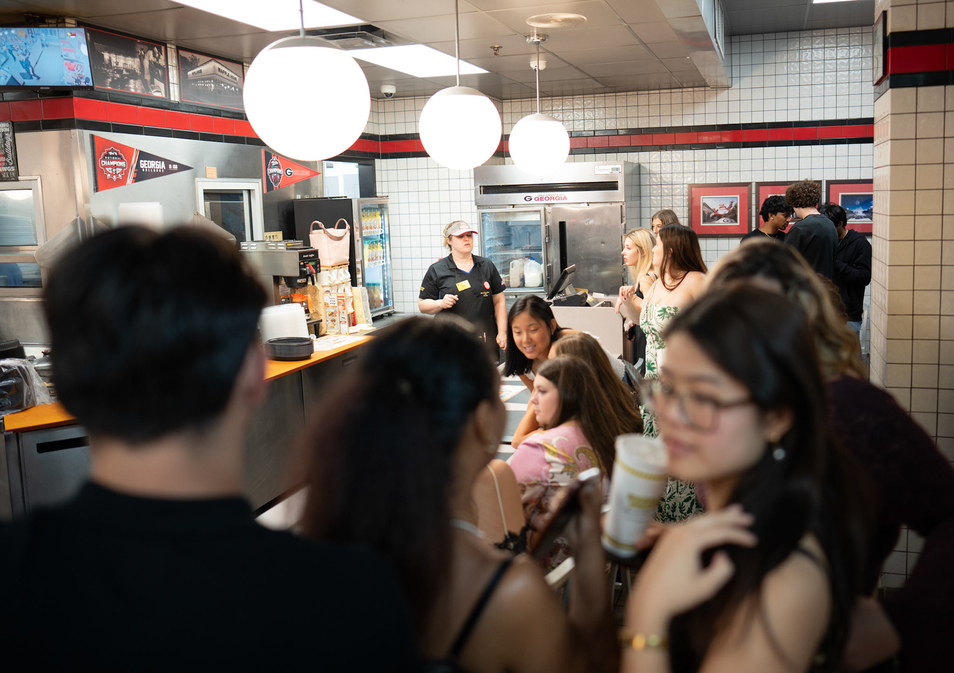 The 2 a.m. crowd fills Waffle House on Clayton Street on Friday, March 27, 2026 in Athens, Georgia. The restaurant is quiet until late during third shift when people come for a post-bars meal. (Photo/Evan Frilingos)